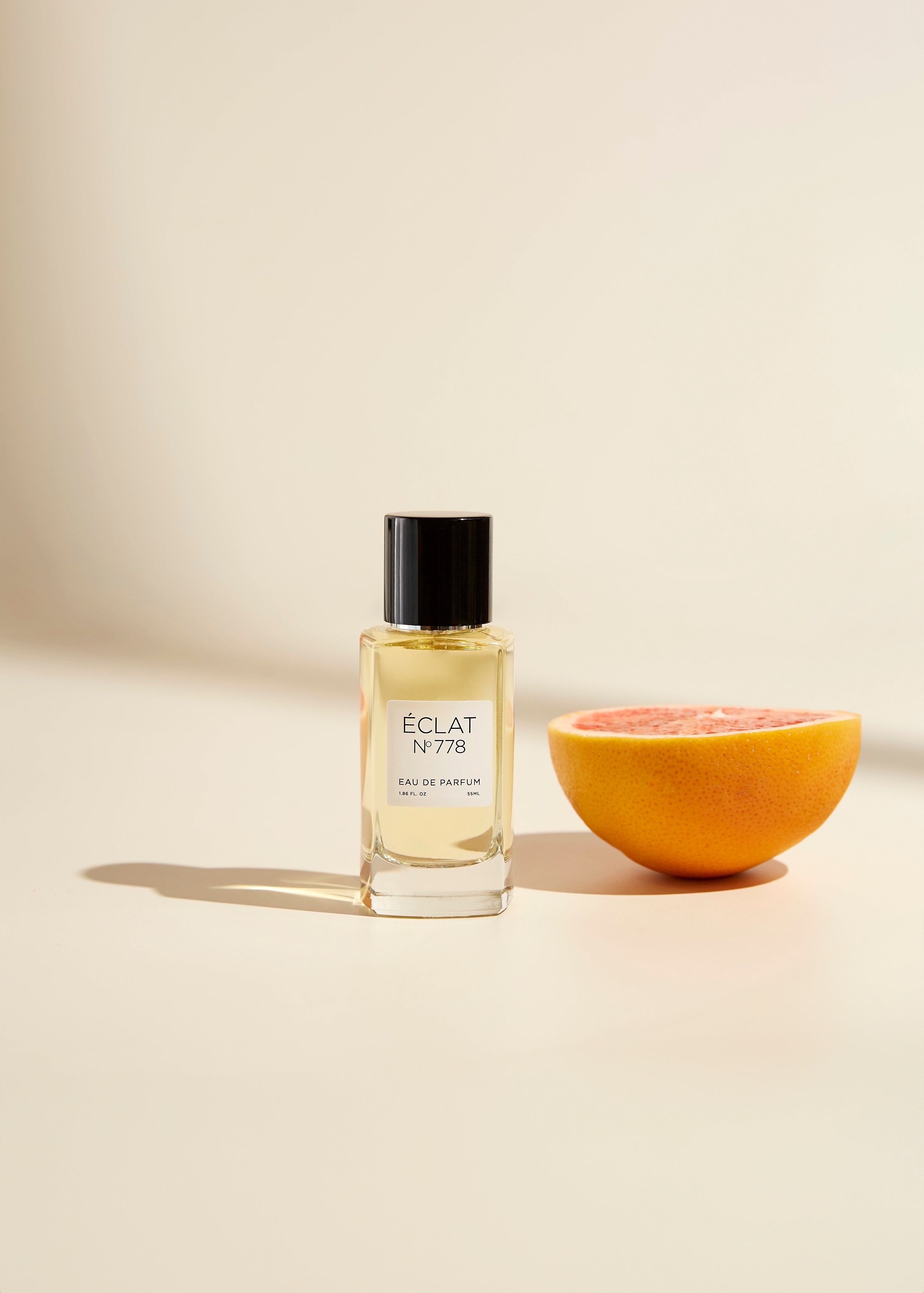 ÉCLAT 778 Sweet Spices & Tobacco men's perfume bottle with citrus slice – hero image for the ÉCLAT Summer Collection for men 2025, highlighting fresh, vibrant summer scents.