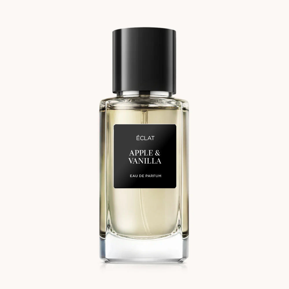 Fragranza ÉCLAT Apple & Vanilla in un flacone di vetro sfaccettato trasparente con tappo nero e etichetta nera elegante.