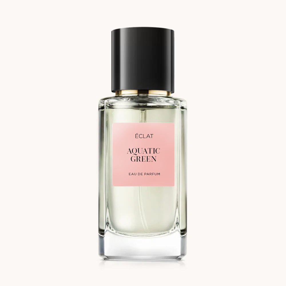 Profumo ÉCLAT Aquatic Green in un flacone di vetro sfaccettato con etichetta rosa e tappo nero.