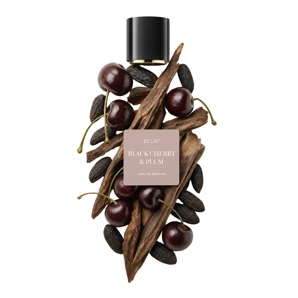 Una disposizione di ciliegie scure, legno di prugna e fagioli tonka circonda un tappo nero con etichetta ÉCLAT Black Cherry & Plum.