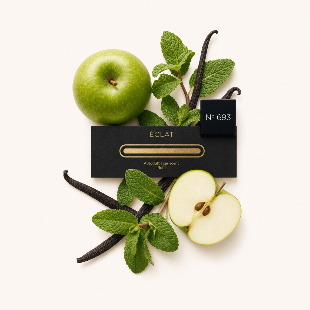 Una composizione di mela verde, foglie di menta fresca e baccelli di vaniglia circonda un tappo nero ÉCLAT No 693 con etichetta.