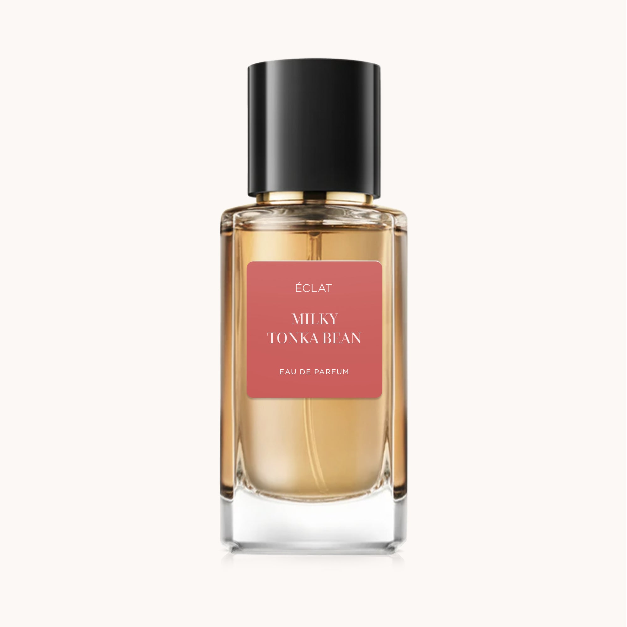 Flacone in vetro sfaccettato con tappo nero ed etichetta ÉCLAT Milky Tonka Bean su sfondo morbido.