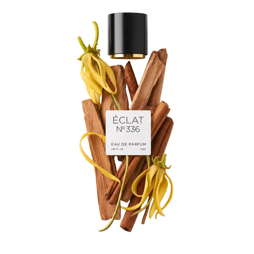 Una composizione di fiori di ylang-ylang gialli e bastoncini di sandalo accompagna un tappo nero con etichetta per ÉCLAT Powdery Sandalwood.