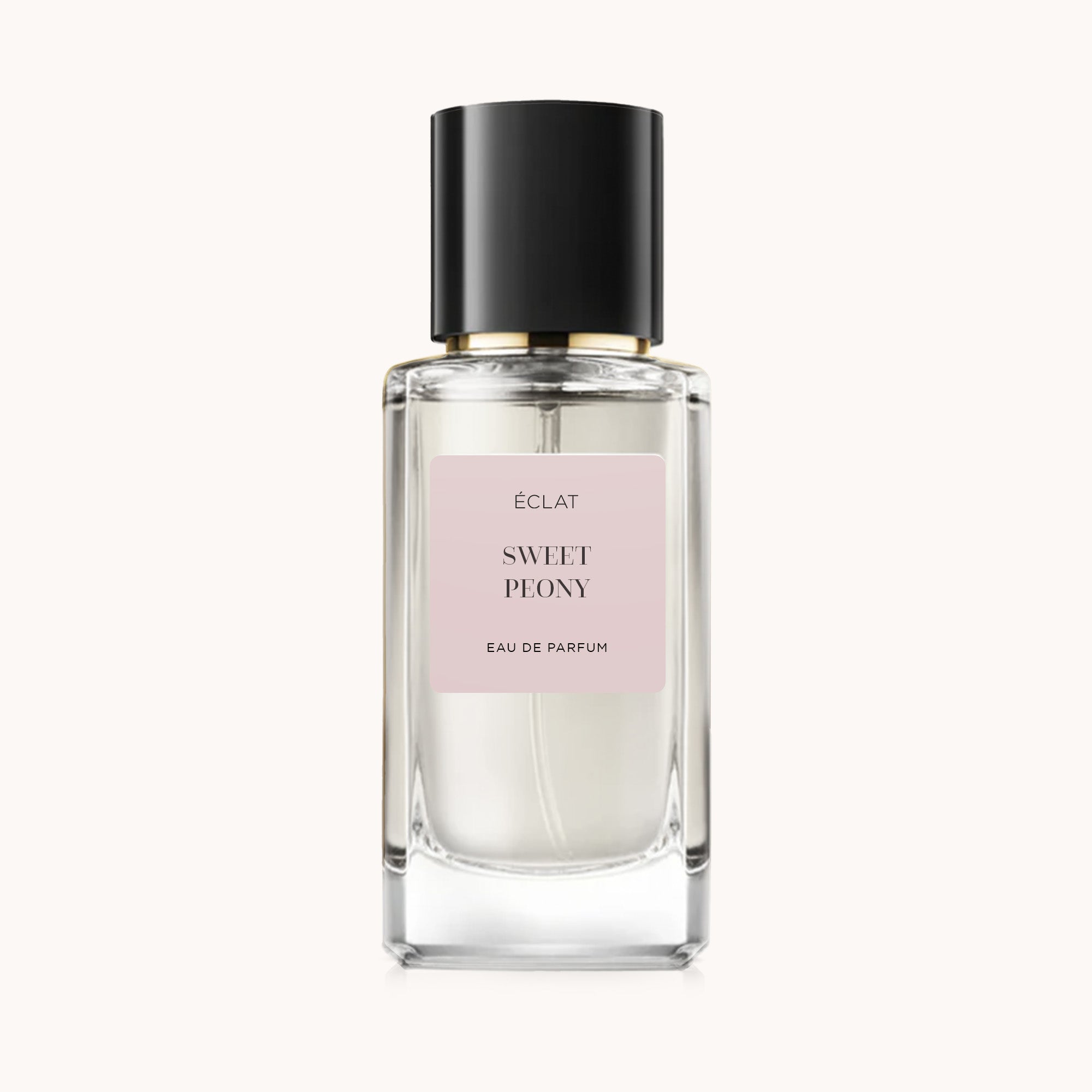 Elegante profumo ÉCLAT Sweet Peony in un flacone di vetro trasparente con tappo nero e etichetta rosa tenue.