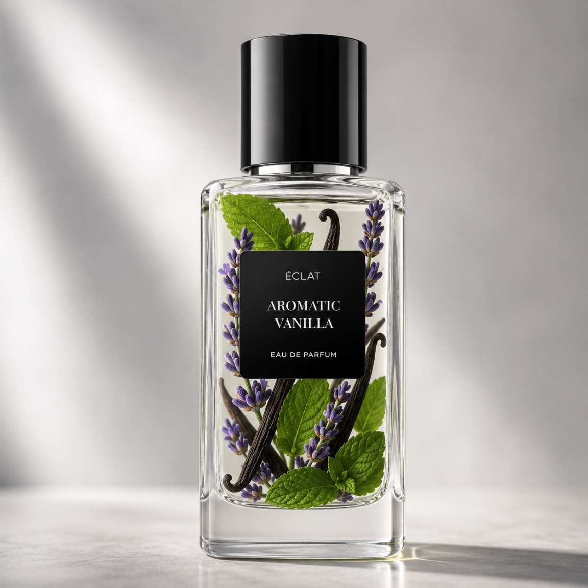 Elegante flacone in vetro di ÉCLAT Aromatic Vanilla, con etichetta nera, ramoscelli di lavanda, baccelli di vaniglia e foglie di menta all'interno.