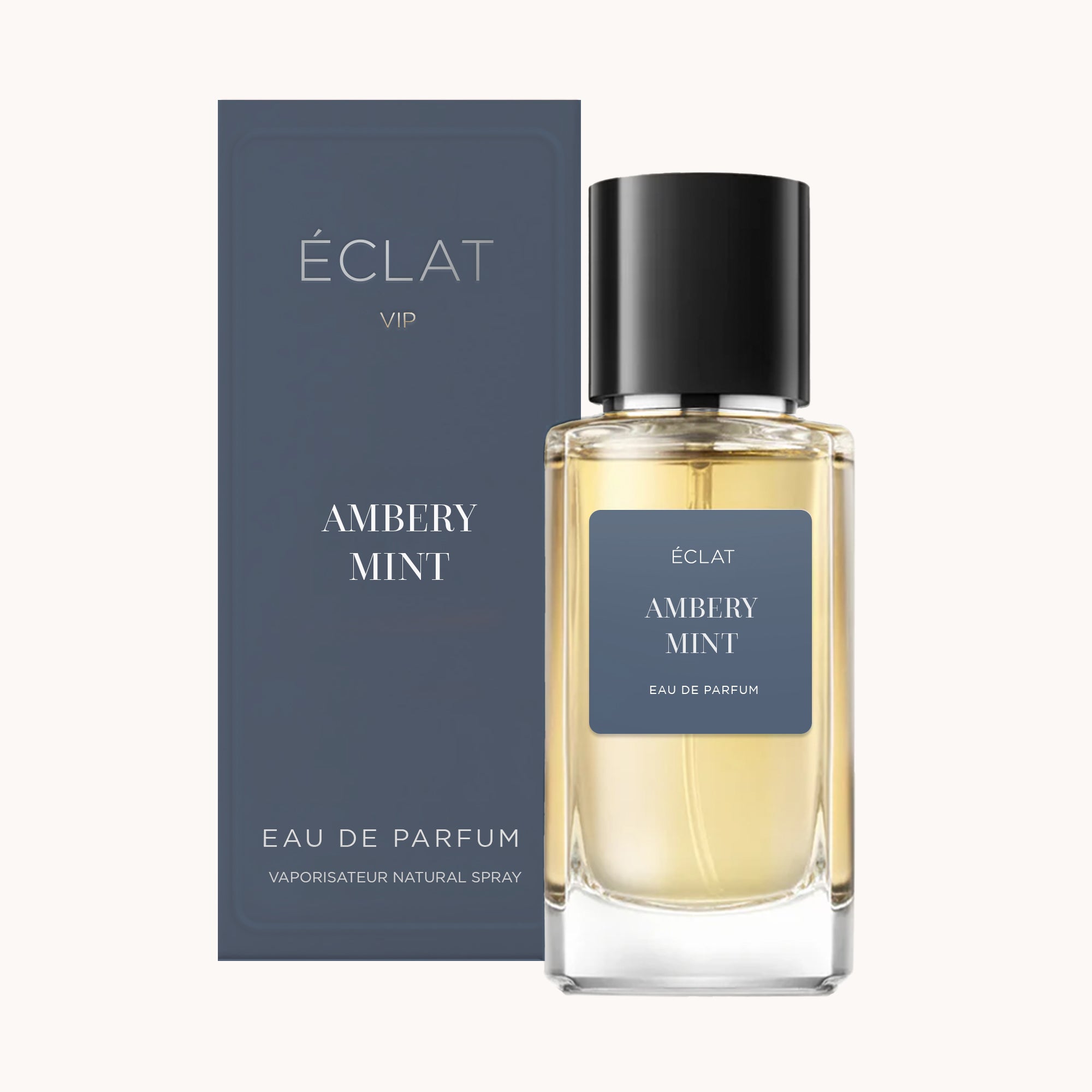 Il profumo ÉCLAT Ambery Mint VIP è presentato in un flacone di vetro trasparente con tappo nero, accompagnato da una confezione blu scuro coordinata.