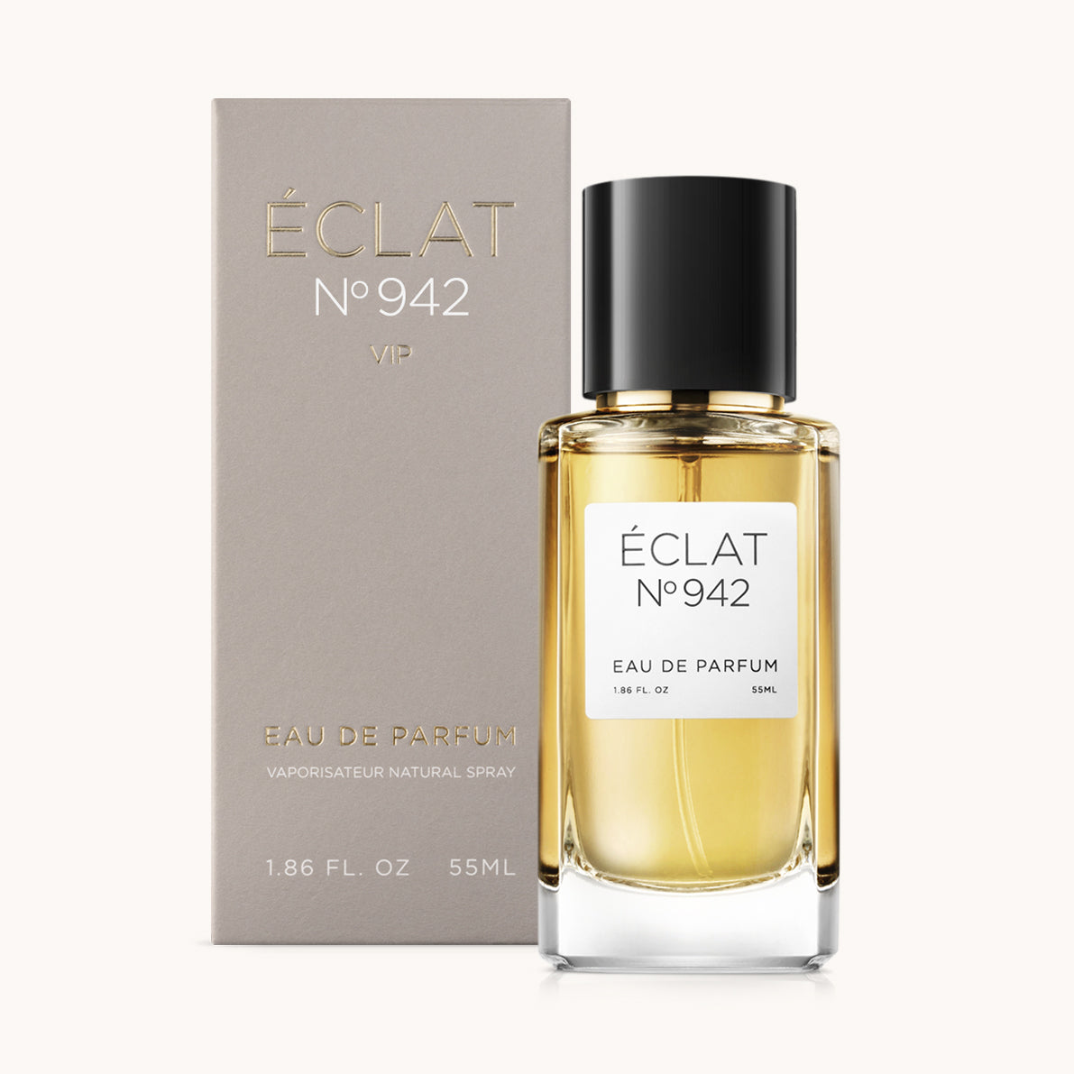Il profumo ÉCLAT Ambery Musk presenta un raffinato flacone di vetro con tappo nero, accanto al suo elegante packaging grigio.