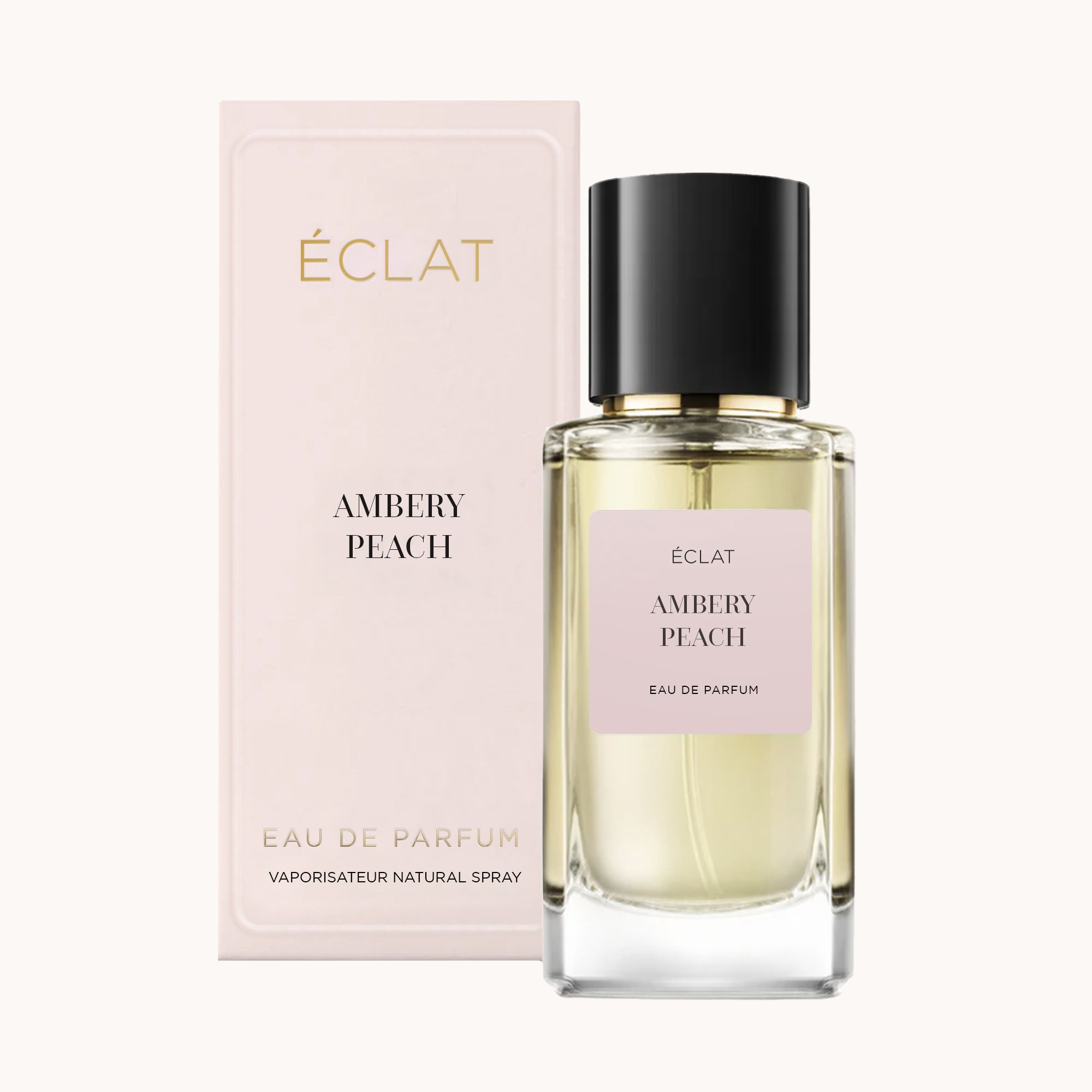 Elegante flacone in vetro di ÉCLAT Ambery Peach con tappo nero, accompagnato da una scatola rosa pallido che mostra il marchio e il nome della fragranza.
