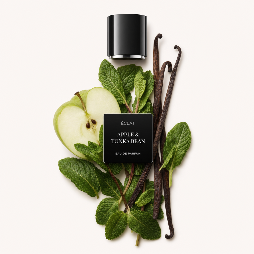 Un arrangiamento con fette di mela fresca e foglie di menta verde, abbinato a baccelli di vaniglia e sormontato da un tappo nero con etichetta ÉCLAT Apple & Tonka Bean.