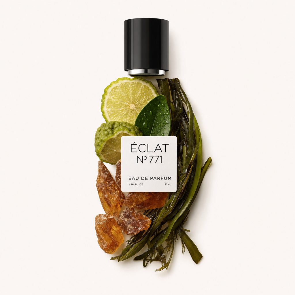 Una natura morta disposta a mano con gli ingredienti di ÉCLAT Aquatic Ambroxide con fette di lime, foglie di ulivo, cristalli d'ambra e alghe, con un tappo nero e un'etichetta in cima.