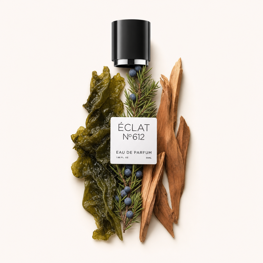 Un tappo nero con etichetta di ÉCLAT Aquatic Cedar si trova tra un composizione di alghe verdi, bacche di ginepro e scaglie di legno di cedro.
