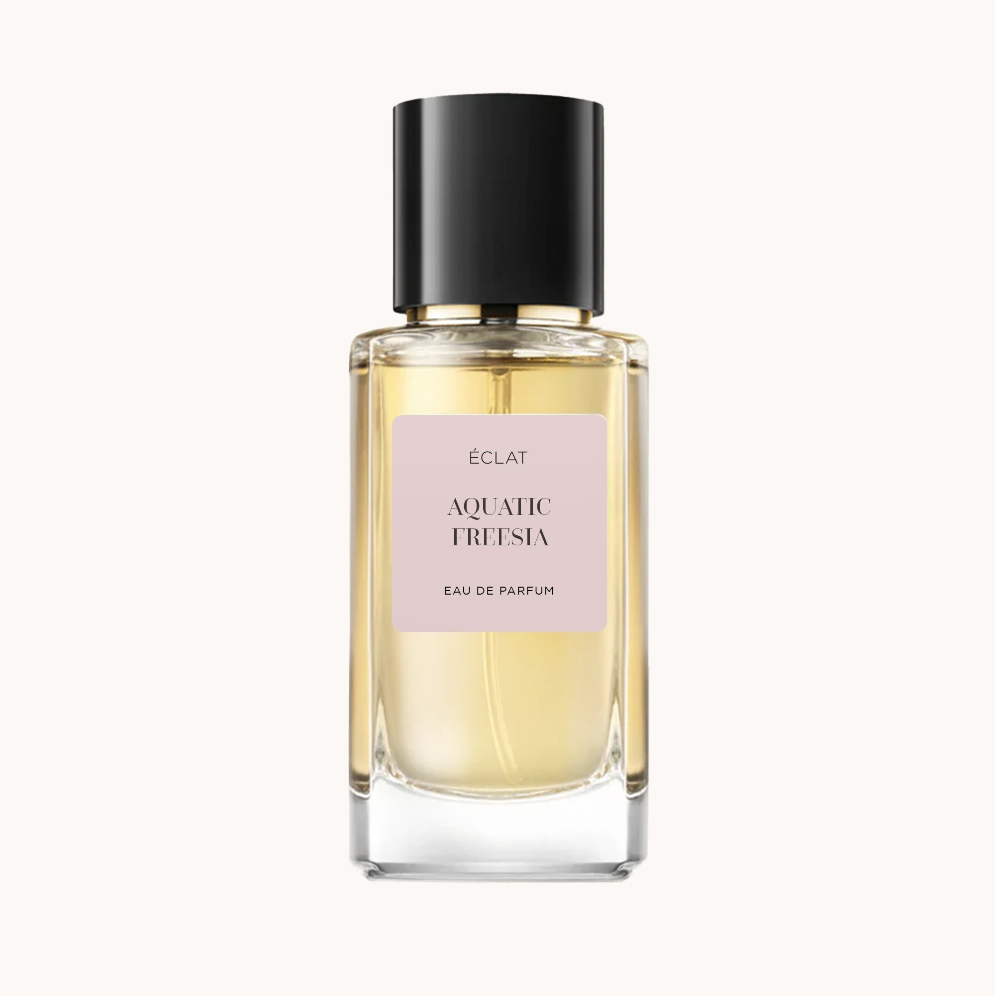 Un flacone in vetro sfaccettato di ÉCLAT Aquatic Freesia con un elegante tappo nero e un'etichetta rosa tenue.