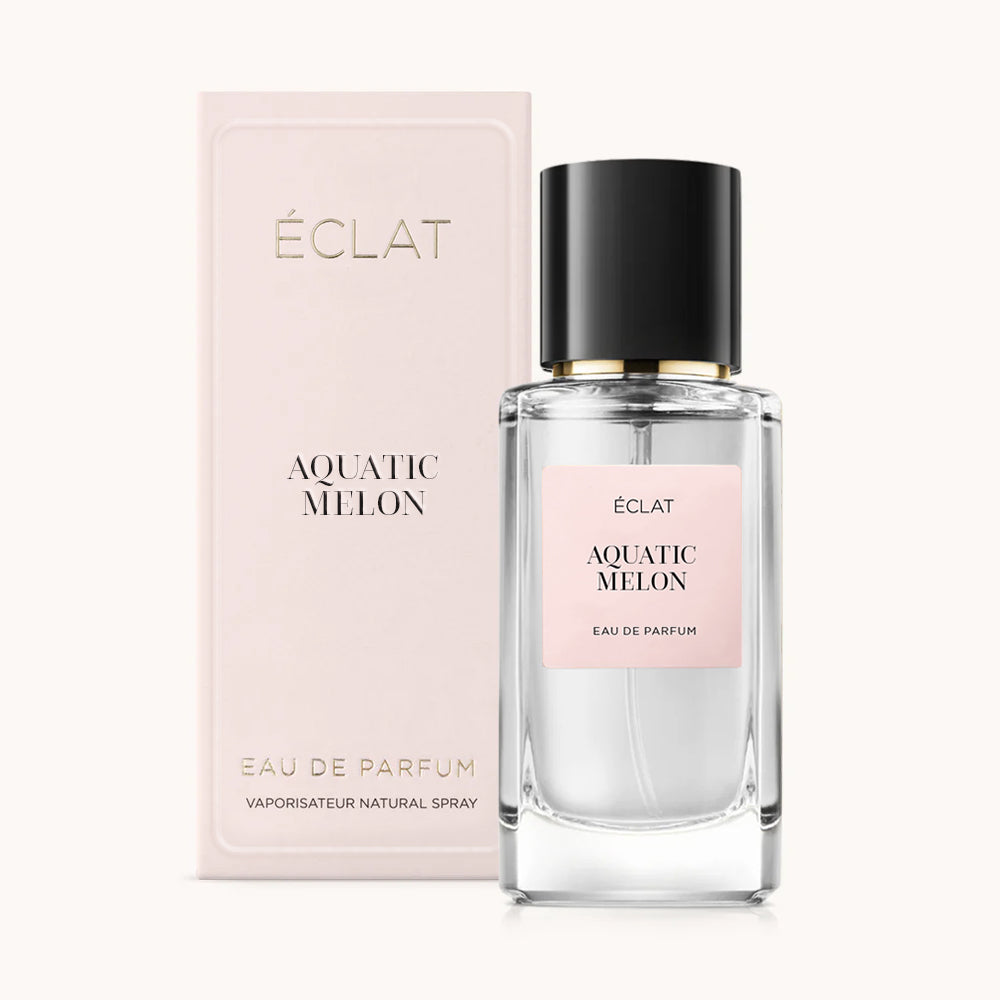 Flacone in vetro sfaccettato di ÉCLAT Aquatic Melon con tappo nero, accanto a una confezione regalo rosa chiaro.