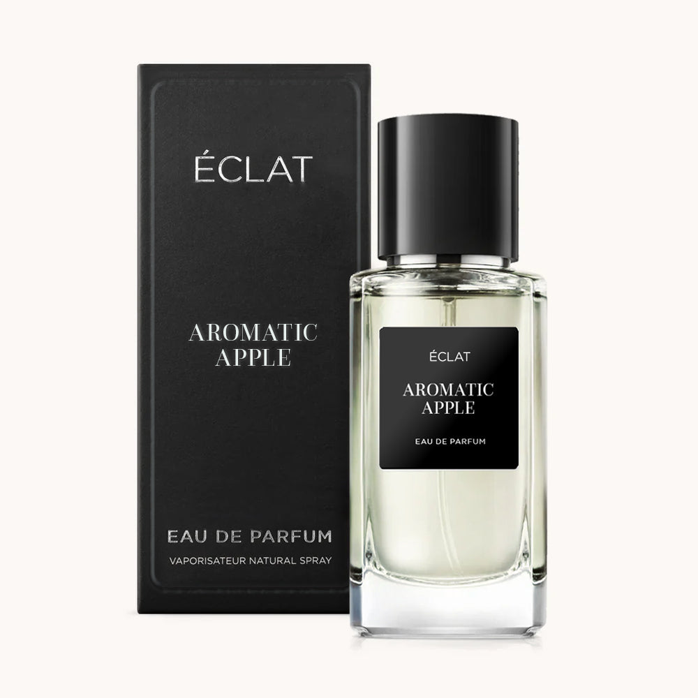 Una bottiglia di vetro trasparente di ÉCLAT Aromatic Apple con etichetta e tappo neri, accompagnata da una elegante scatola nera.