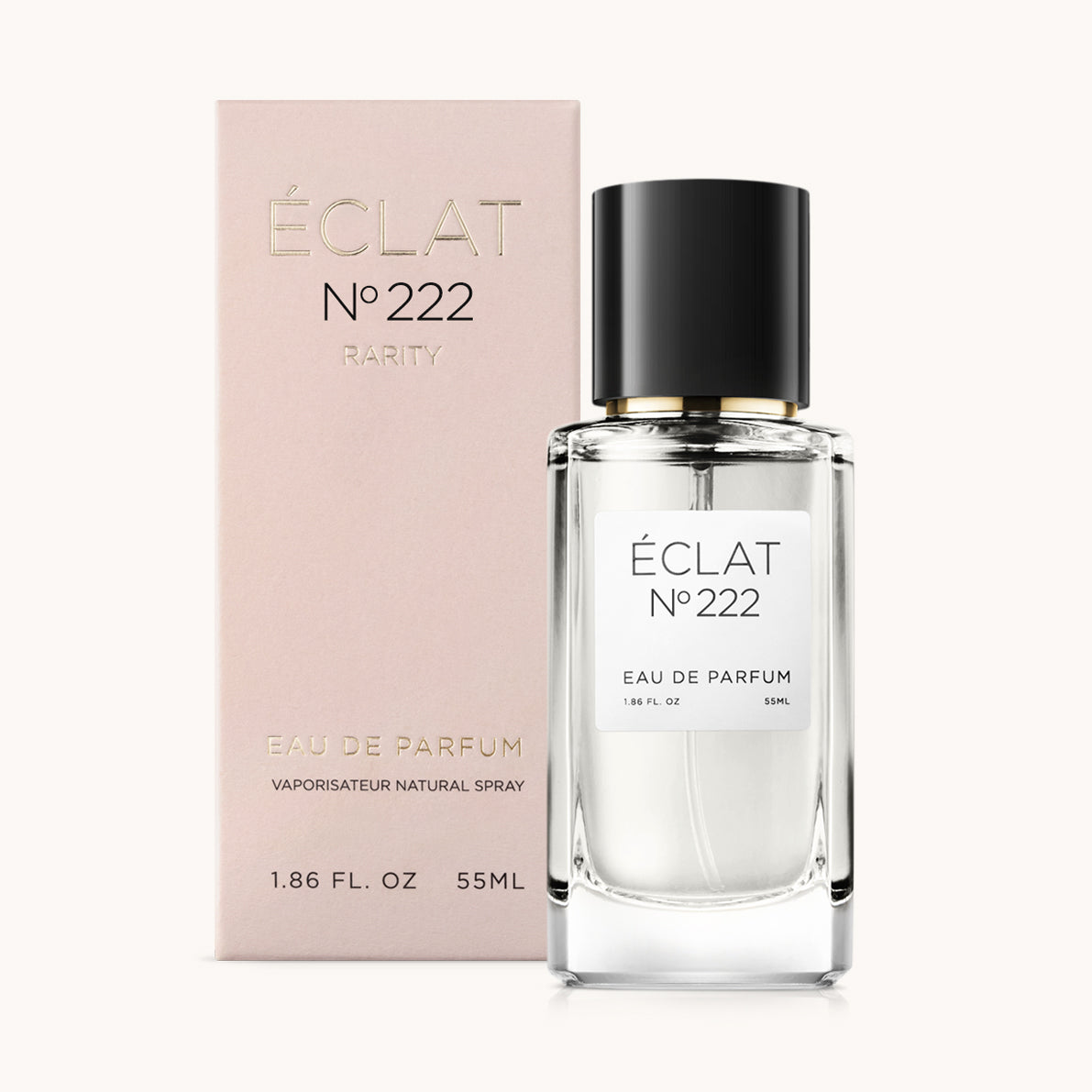 Un flacone di vetro sfaccettato con tappo nero davanti a una scatola rosa pastello con l'iscrizione ÉCLAT Berries & Cedar.