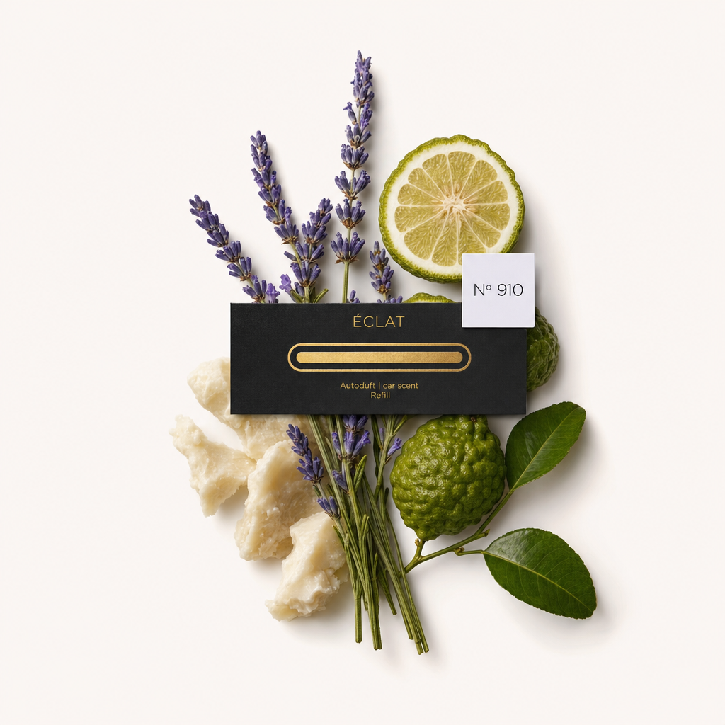 Un arrangiamento di rametti di lavanda, una fetta di bergamotto e foglie verdi circonda un tappo nero con etichetta ÉCLAT, contrassegnato No 910.