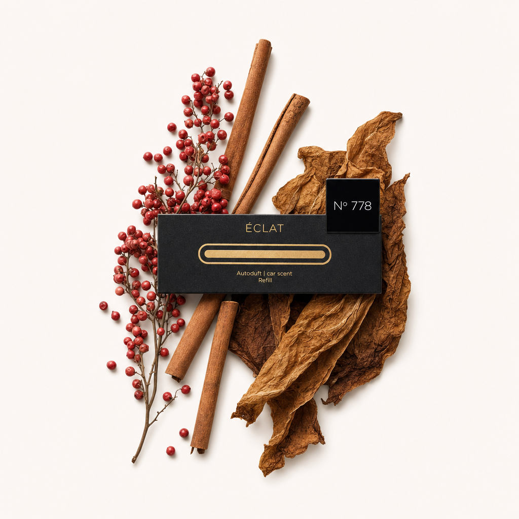 Un sofisticato arrangiamento di bacche di pepe rosso, stecche di cannella e foglie di tabacco circonda un tappo nero con etichetta ÉCLAT N° 778.