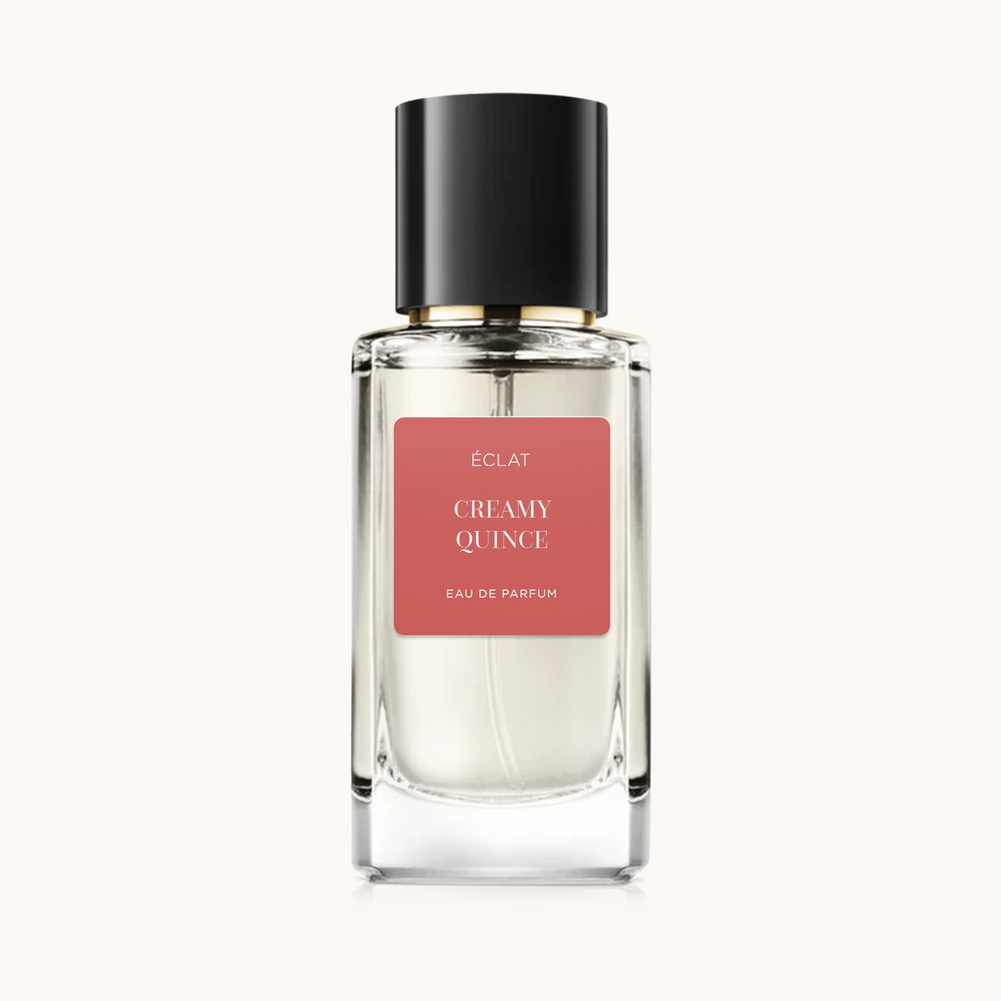 ÉCLAT Creamy Quince in un flacone di vetro sfaccettato con tappo nero e etichetta corallo.