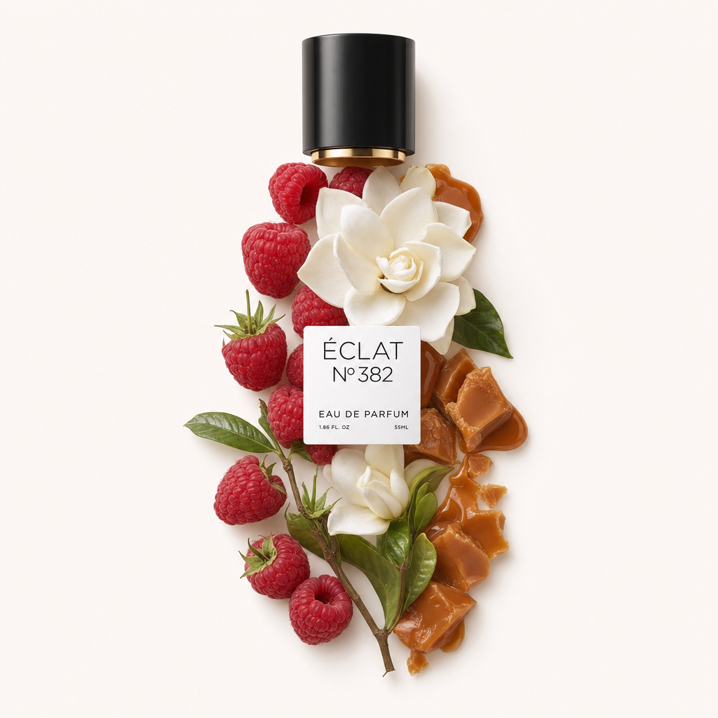 Una composizione di lamponi freschi, fiori bianchi e caramello è disposta artisticamente sotto un tappo nero con etichetta ÉCLAT Creamy Raspberry.