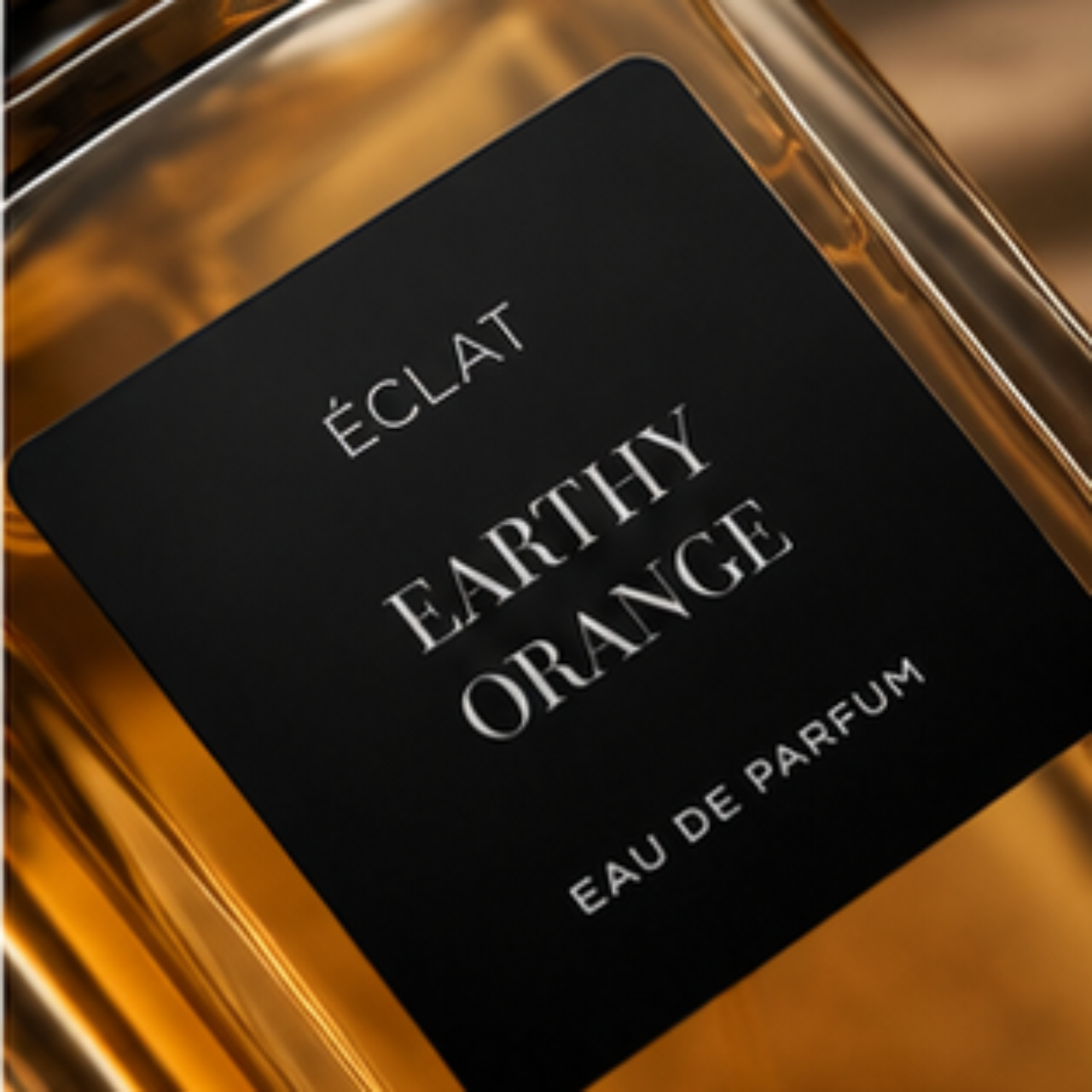 Un flacone in vetro con una calda tonalità ambrata, con un'etichetta nera opaca che riporta ÉCLAT Earthy Orange.