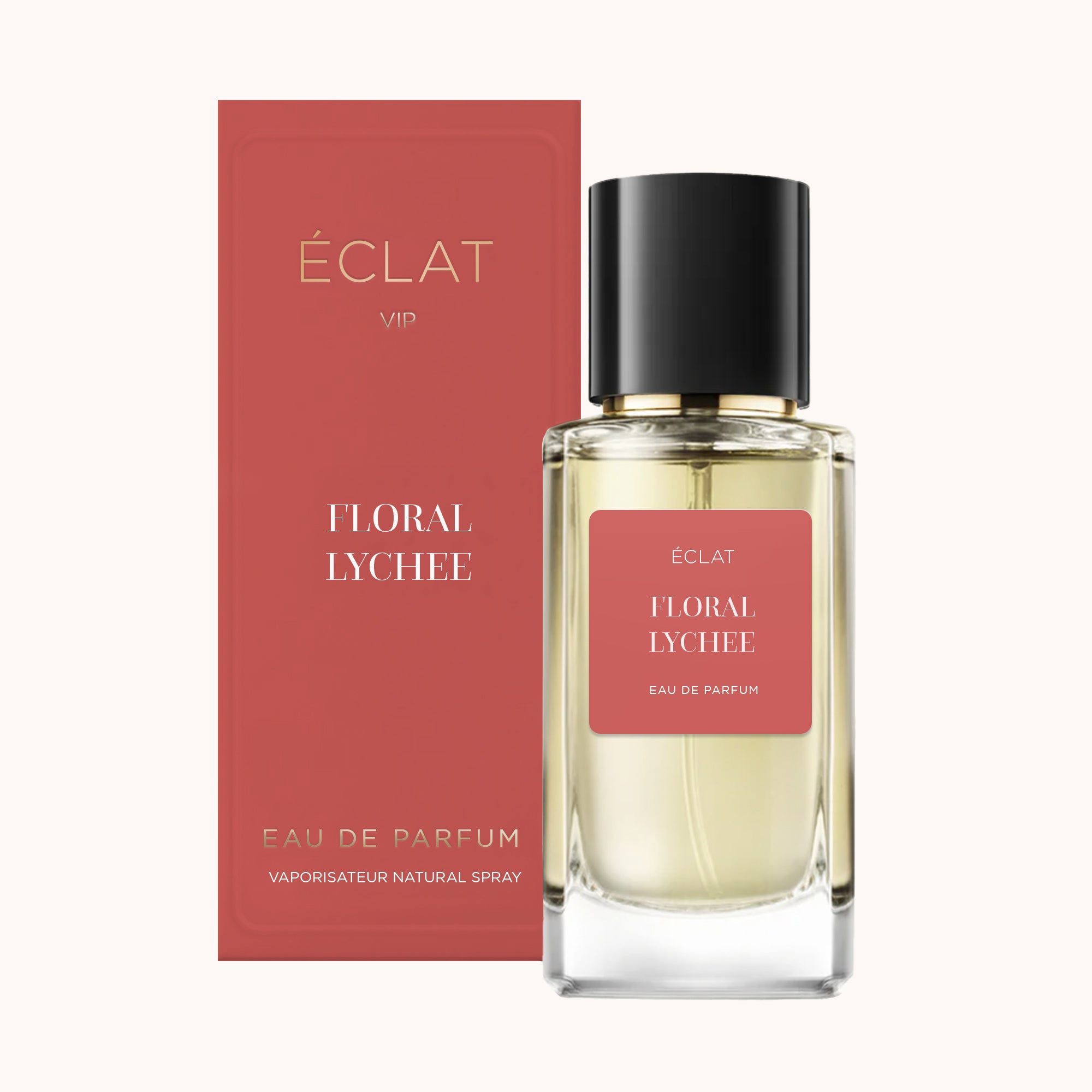 Una bottiglia di vetro sfaccettato di ÉCLAT Floral Lychee con tappo nero, accompagnata da una scatola color corallo in piedi.