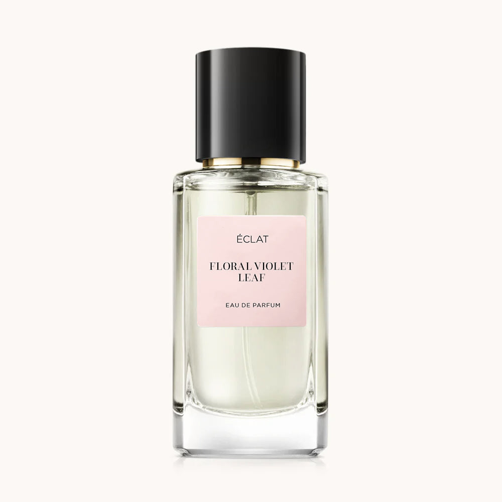 Elegante flacone in vetro con tappo nero ed etichetta rosa pallido del profumo ÉCLAT Floral Violet Leaf.