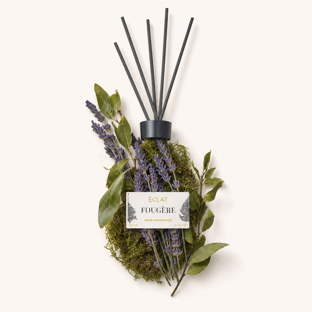 Un arrangiamento con rametti di lavanda e foglie verdi attorno a un tappo nero con etichetta, evidenziando il profumo d'ambiente ÉCLAT Fougère.