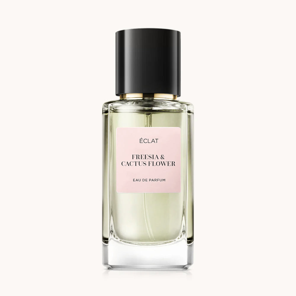 Flacone di vetro sfaccettato con tappo nero e etichetta rosa pallido con ÉCLAT Freesia & Cactus Flower.