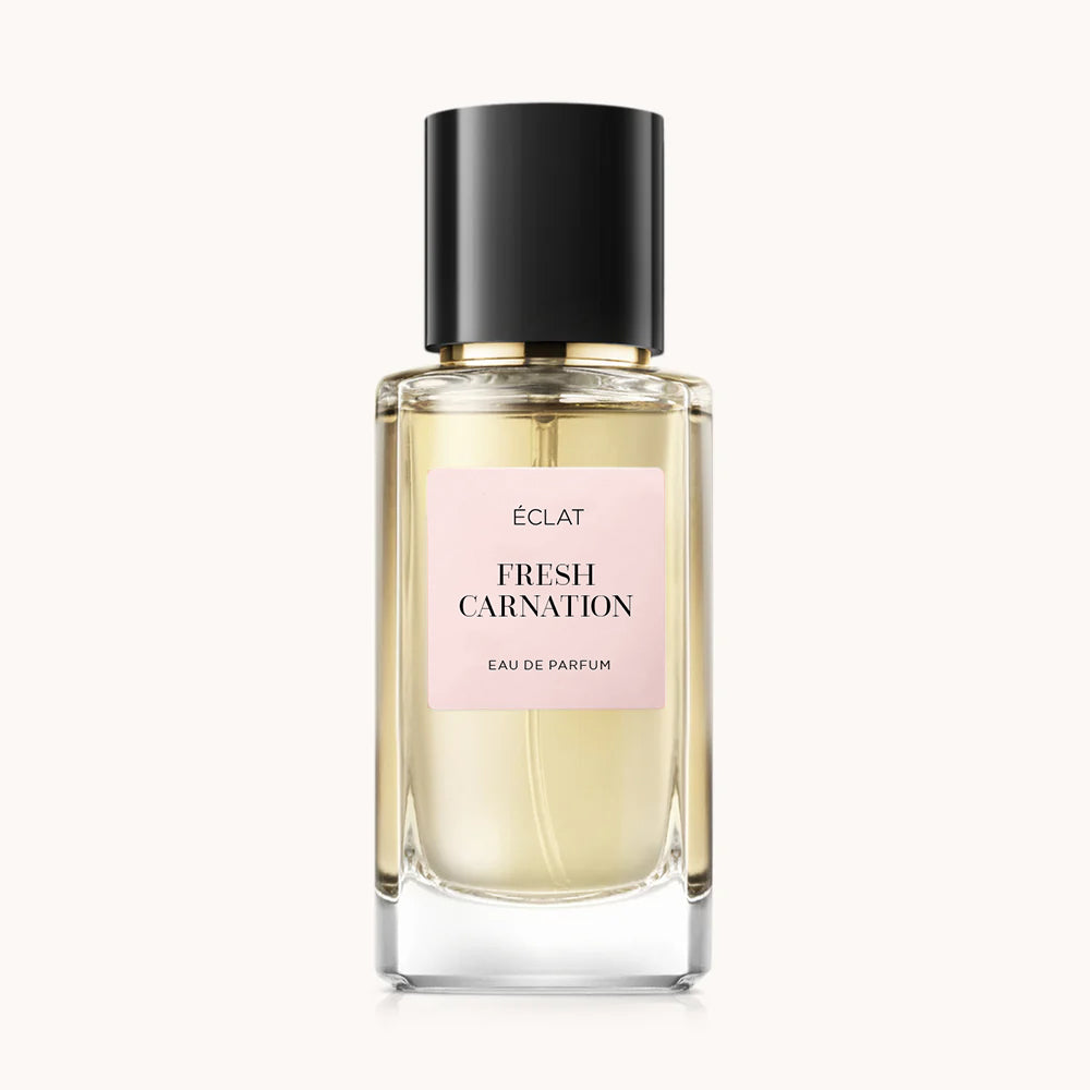 Un flacone di vetro sfaccettato di ÉCLAT Fresh Carnation con tappo nero e un'etichetta rosa tenue.