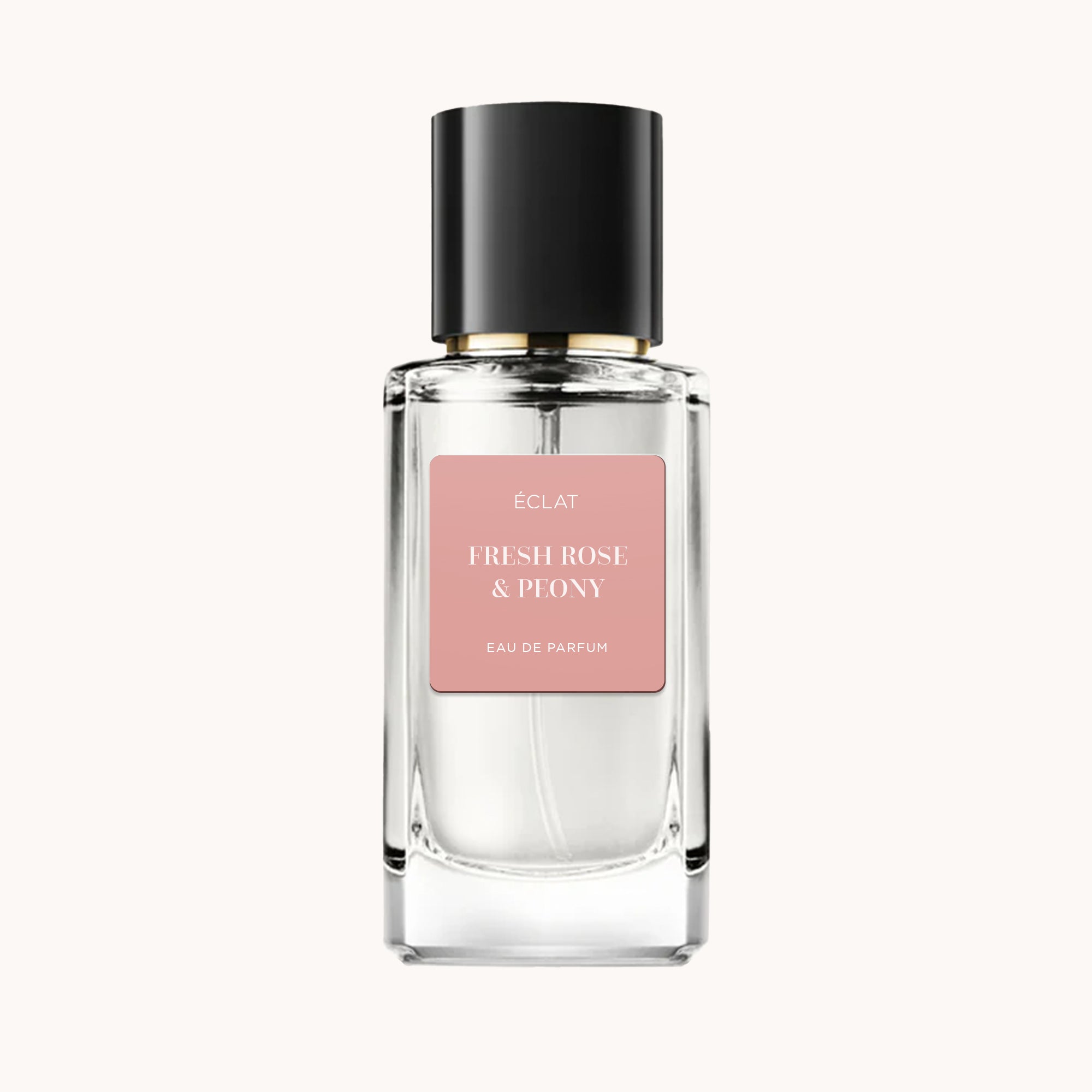 Un flacone in vetro sfaccettato di ÉCLAT Fresh Rose & Peony con etichetta rosa opaca e tappo nero.