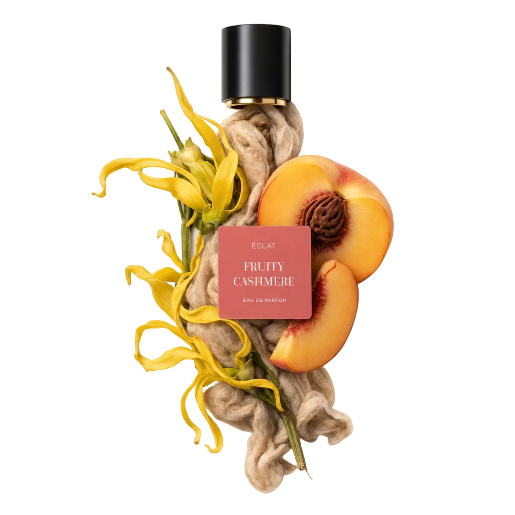 L'immagine mostra un arrangiamento di fiori di ylang-ylang gialli, fibre di cashmere morbide e una pesca matura, con il tappo nero originale con l'etichetta ÉCLAT Fruity Cashmere.