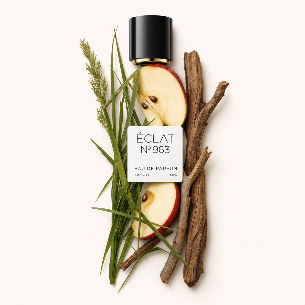 Un arrangiamento di fette di mela, erba fresca e bastoncini di legno circonda un tappo nero con etichetta di ÉCLAT Fruity Grass.