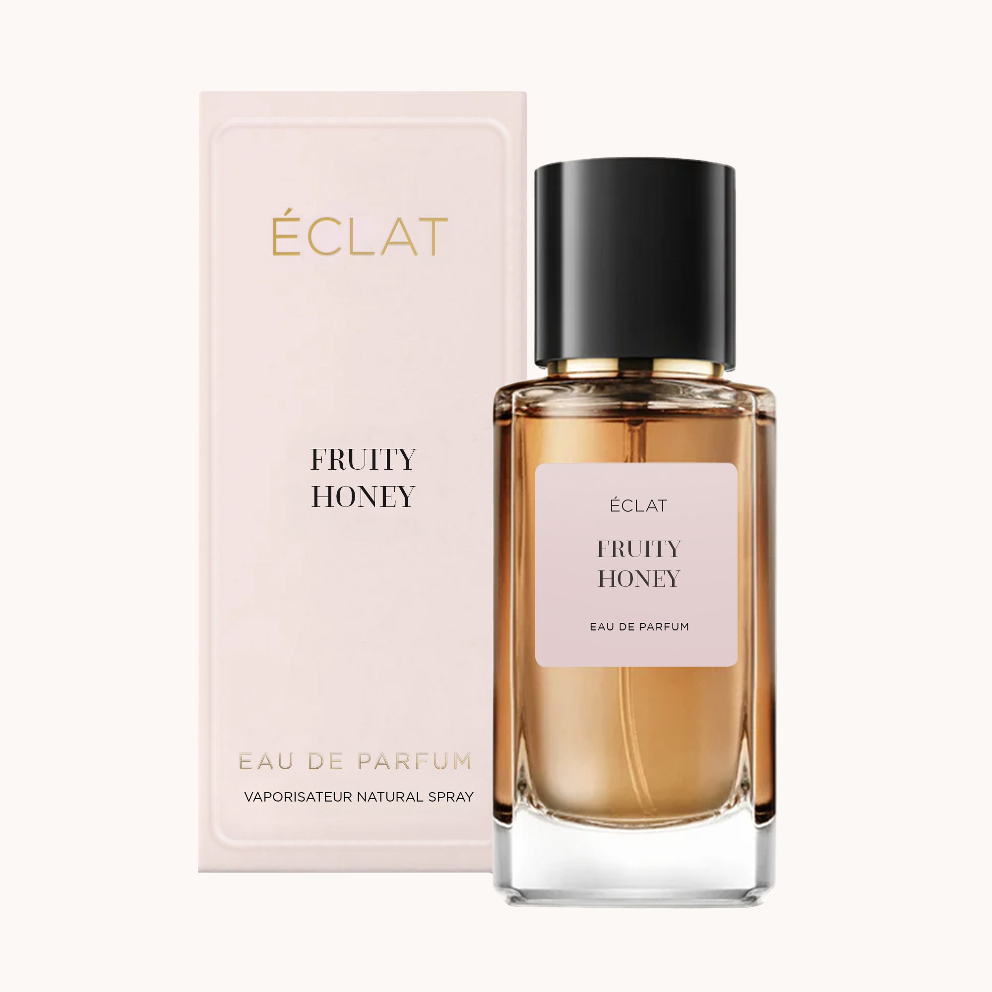 Un flacone in vetro sfaccettato di ÉCLAT Fruity Honey con tappo nero, posizionato davanti a una confezione rosa tenue.