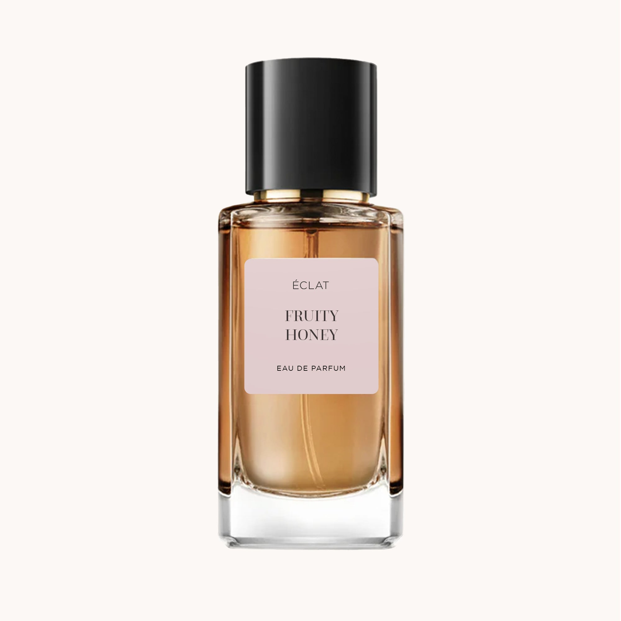 Boccetta di profumo ÉCLAT Fruity Honey con design in vetro trasparente e tappo nero.