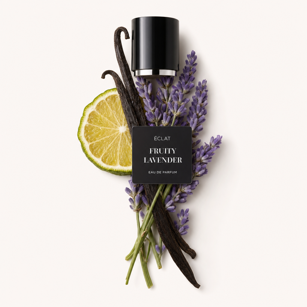 Un arrangiamento di baccelli di vaniglia, rametti di lavanda e una fetta di lime circondano un tappo nero con etichetta ÉCLAT Fruity Lavender.