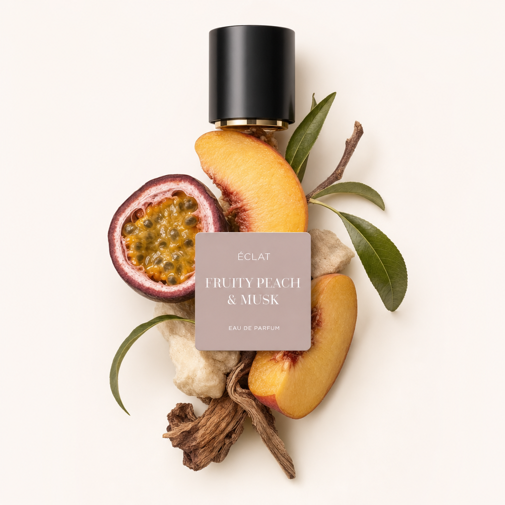 Una composizione di fette di pesca, frutto della passione, foglie verdi ed elementi legnosi circonda il tappo nero con etichetta di ÉCLAT Fruity Peach & Musk.