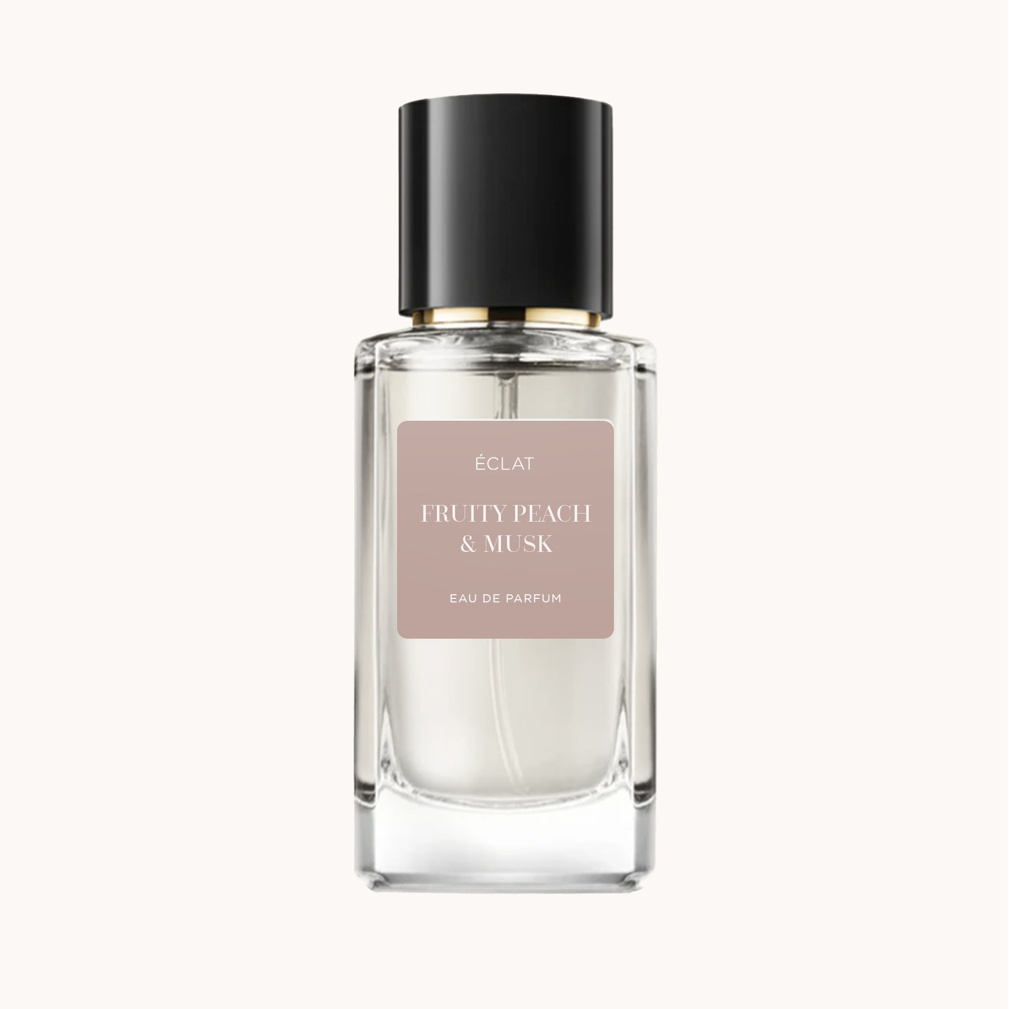 Un flacone di vetro sfaccettato con tappo nero, con l'etichetta 'ÉCLAT Fruity Peach & Musk' su uno sfondo beige tenue.