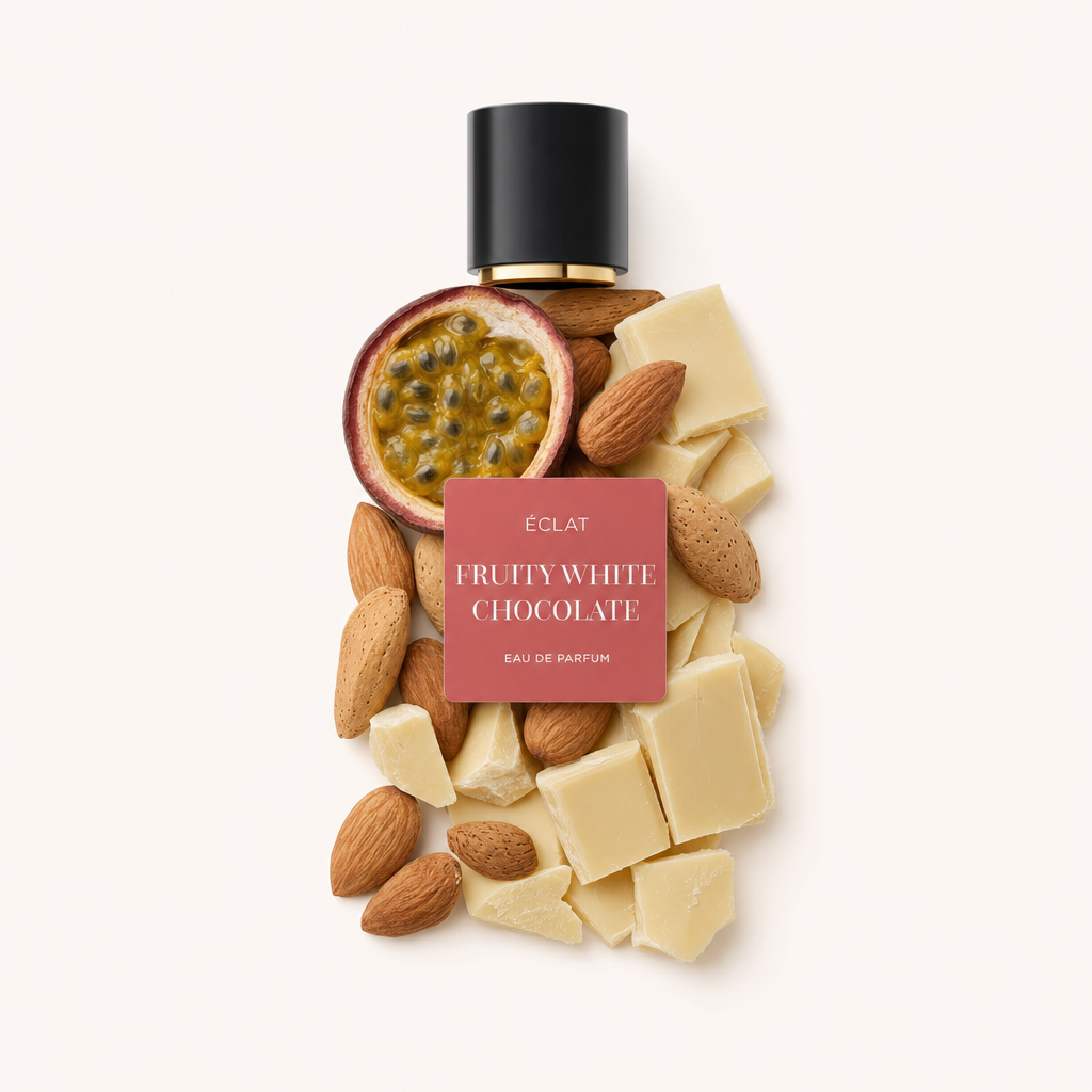 Una disposizione artistica di un frutto della passione a metà, mandorle intere e pezzi di cioccolato bianco cremoso sotto un tappo nero con etichetta per ÉCLAT Fruity White Chocolate.