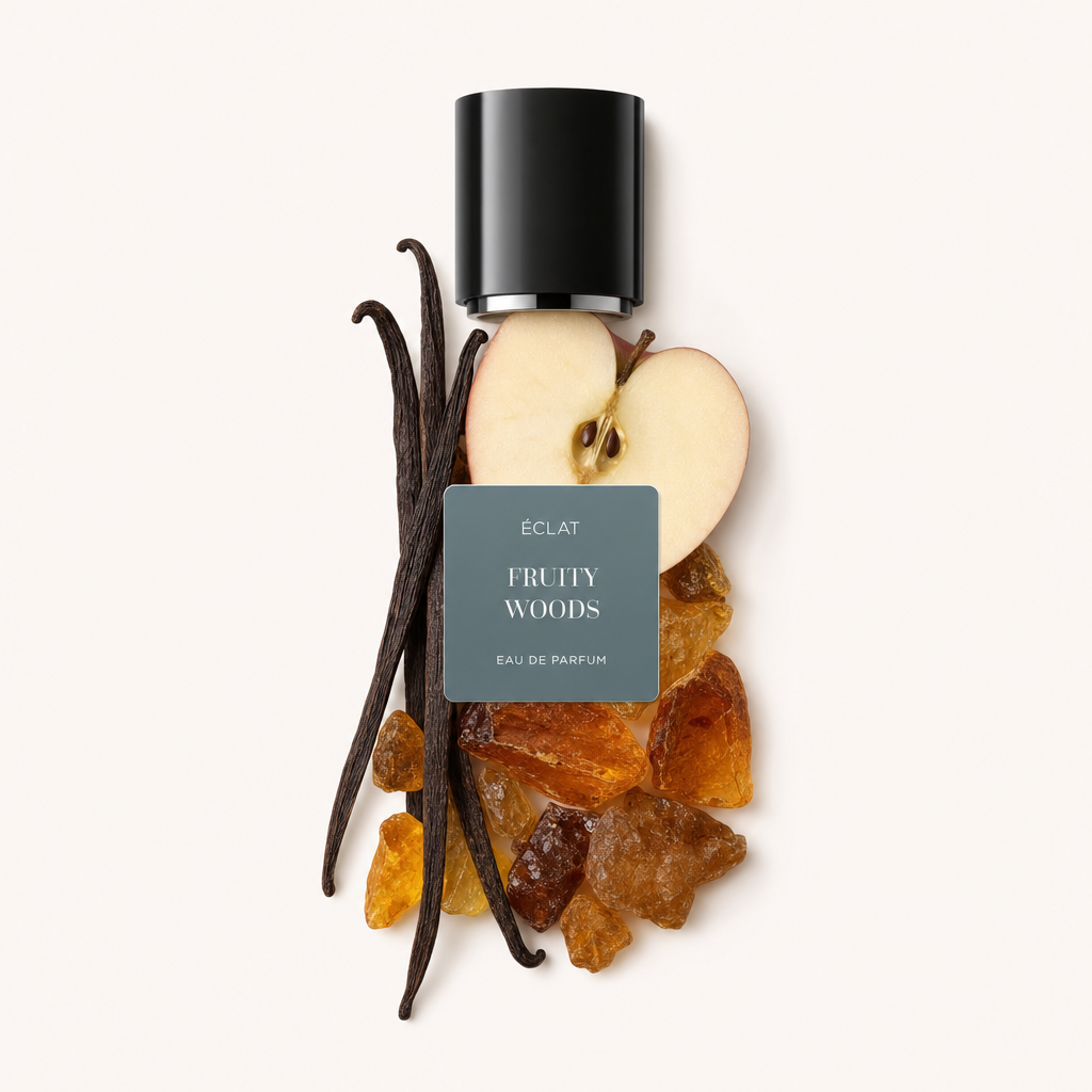 Un arrangiamento di una fetta di mela, baccelli di vaniglia e resine, sormontato da un tappo nero con etichetta ÉCLAT Fruity Woods.