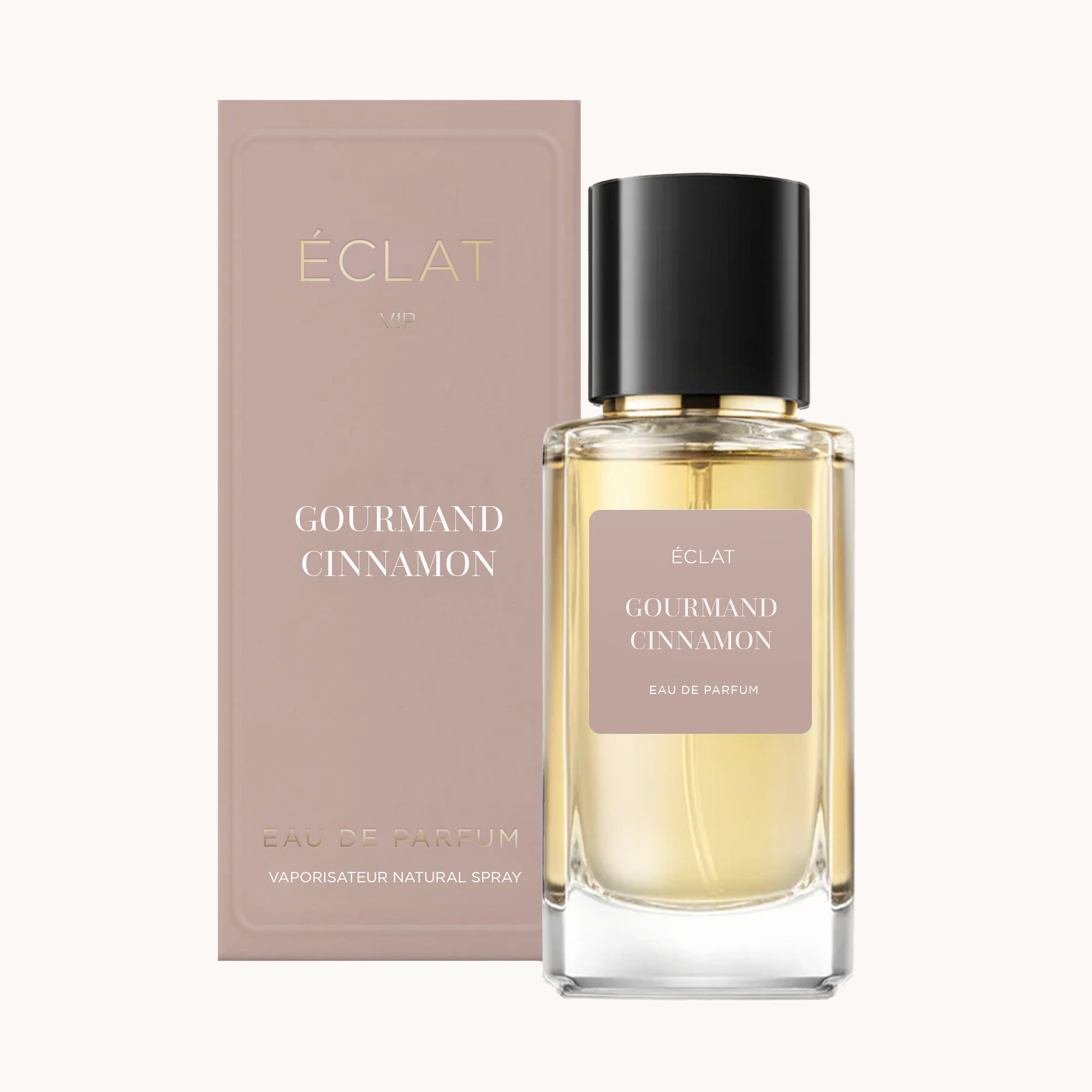 Bottiglia di profumo ÉCLAT Gourmand Cinnamon con design in vetro quadrato e tappo nero elegante accanto a una scatola color taupe.