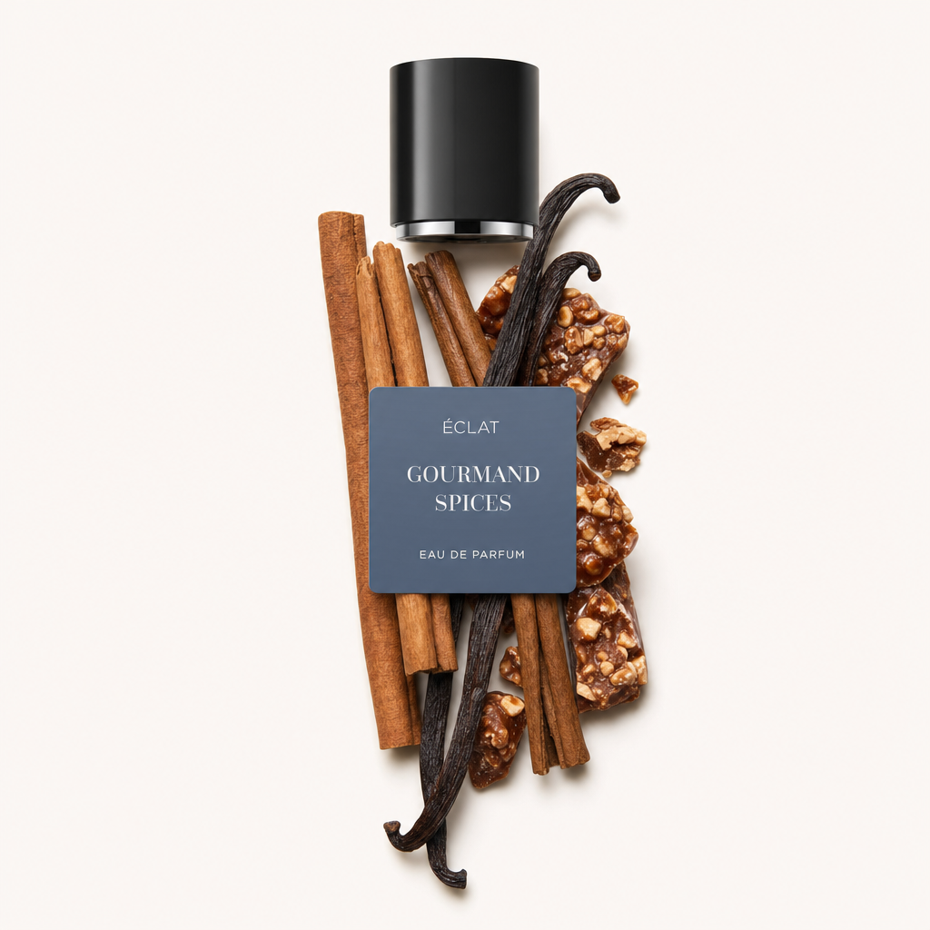 Un arrangiamento di bacche di vaniglia, bastoncini di cannella e pezzi di caramello con un tappo nero etichettato ÉCLAT Gourmand Spices.
