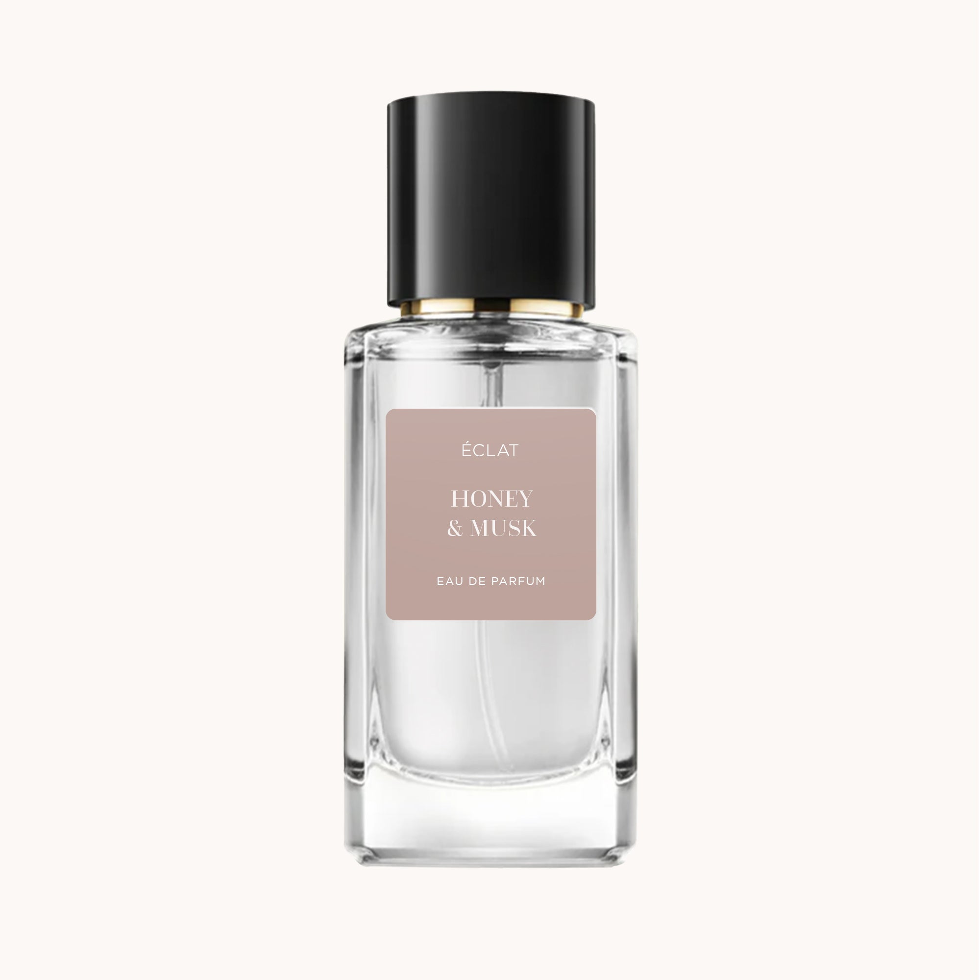 Il profumo ÉCLAT Honey & Musk è presentato in una bottiglia di vetro trasparente con tappo nero e etichetta rosa tenue.