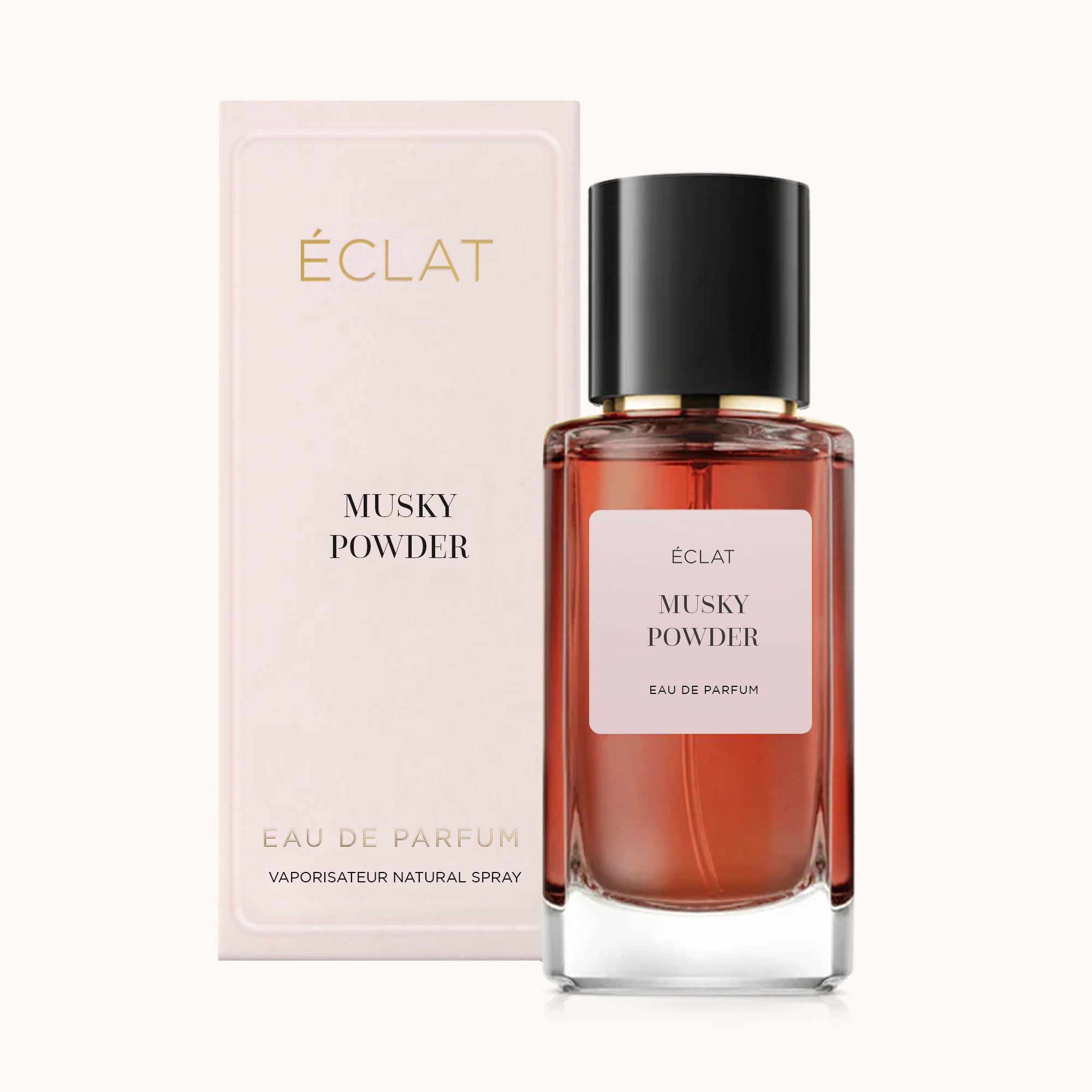 Bottiglia di vetro sfaccettato ÉCLAT Musky Powder con tappo nero, accanto alla sua elegante confezione beige.