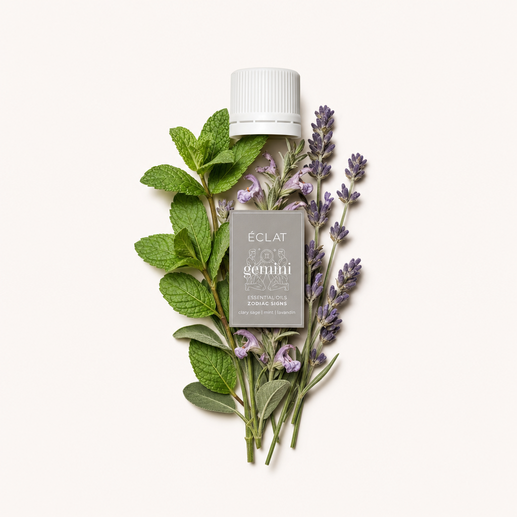Un insieme di rametti di menta e lavanda freschi circonda un tappo bianco con etichetta, presentando l'essenza di ÉCLAT Natural Oil Blend - Zodiac Sign Gemini.