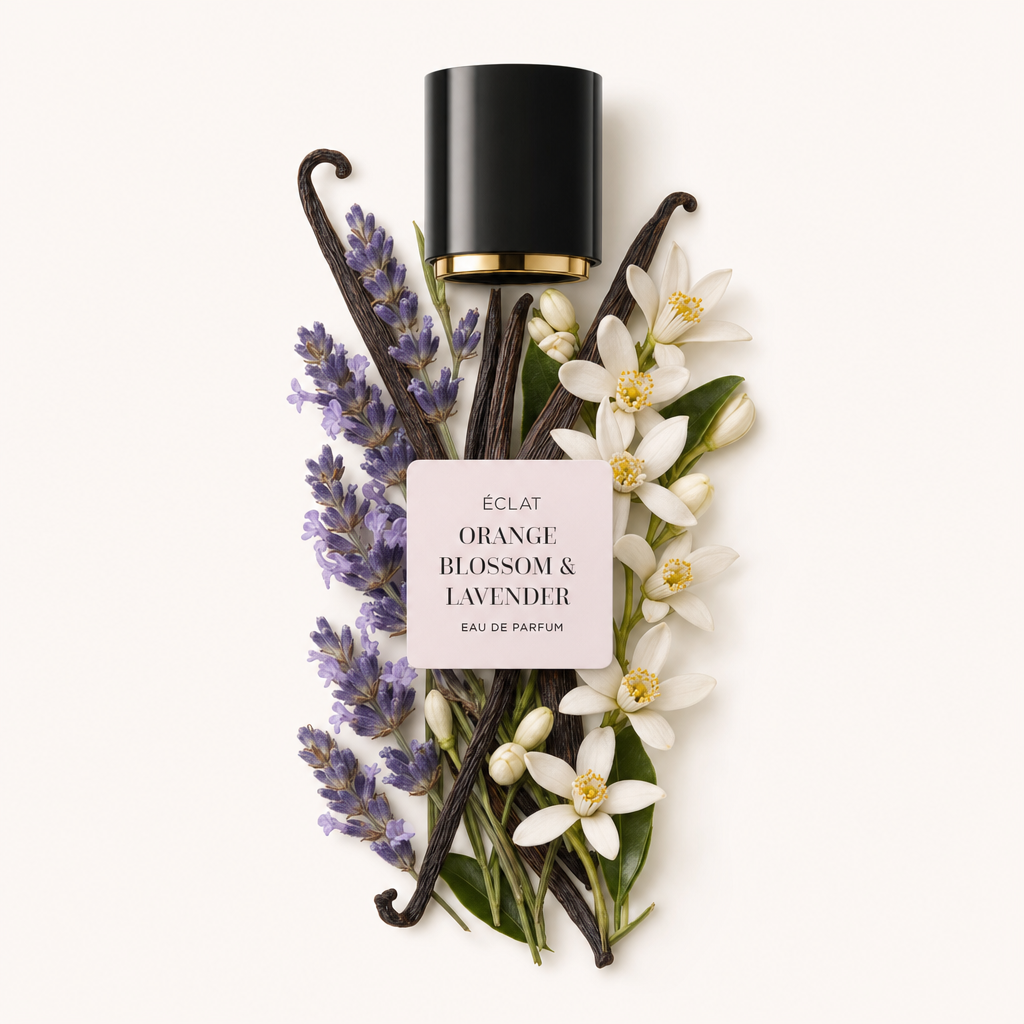 Un arrangiamento curato di spighe di lavanda e fiori d'arancio che circondano baccelli di vaniglia. In alto, un tappo nero con interno dorato reca l'etichetta ÉCLAT Orange Blossom & Lavender.