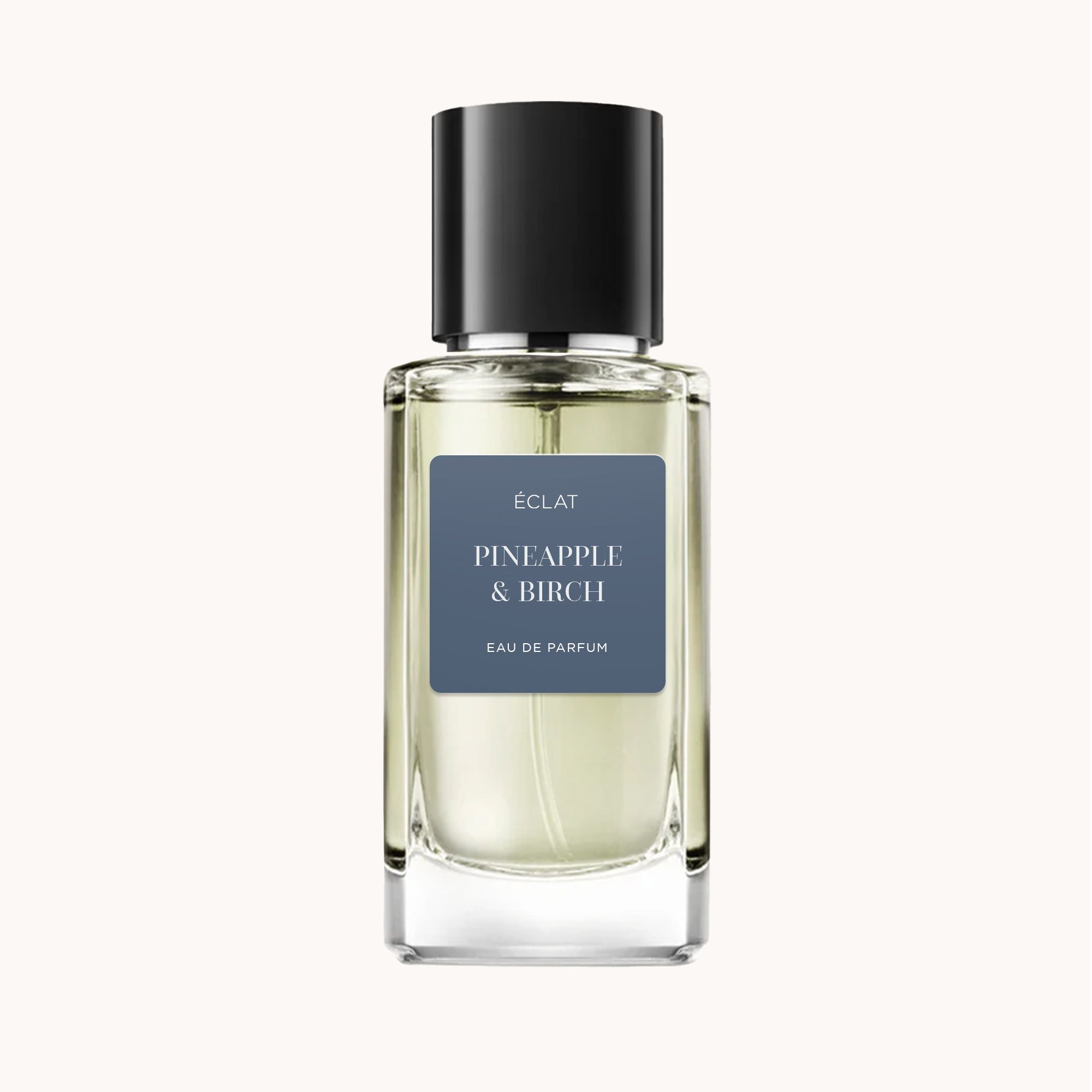La fragranza ÉCLAT Pineapple & Birch in un flacone di vetro trasparente con tappo nero ed etichetta scura.