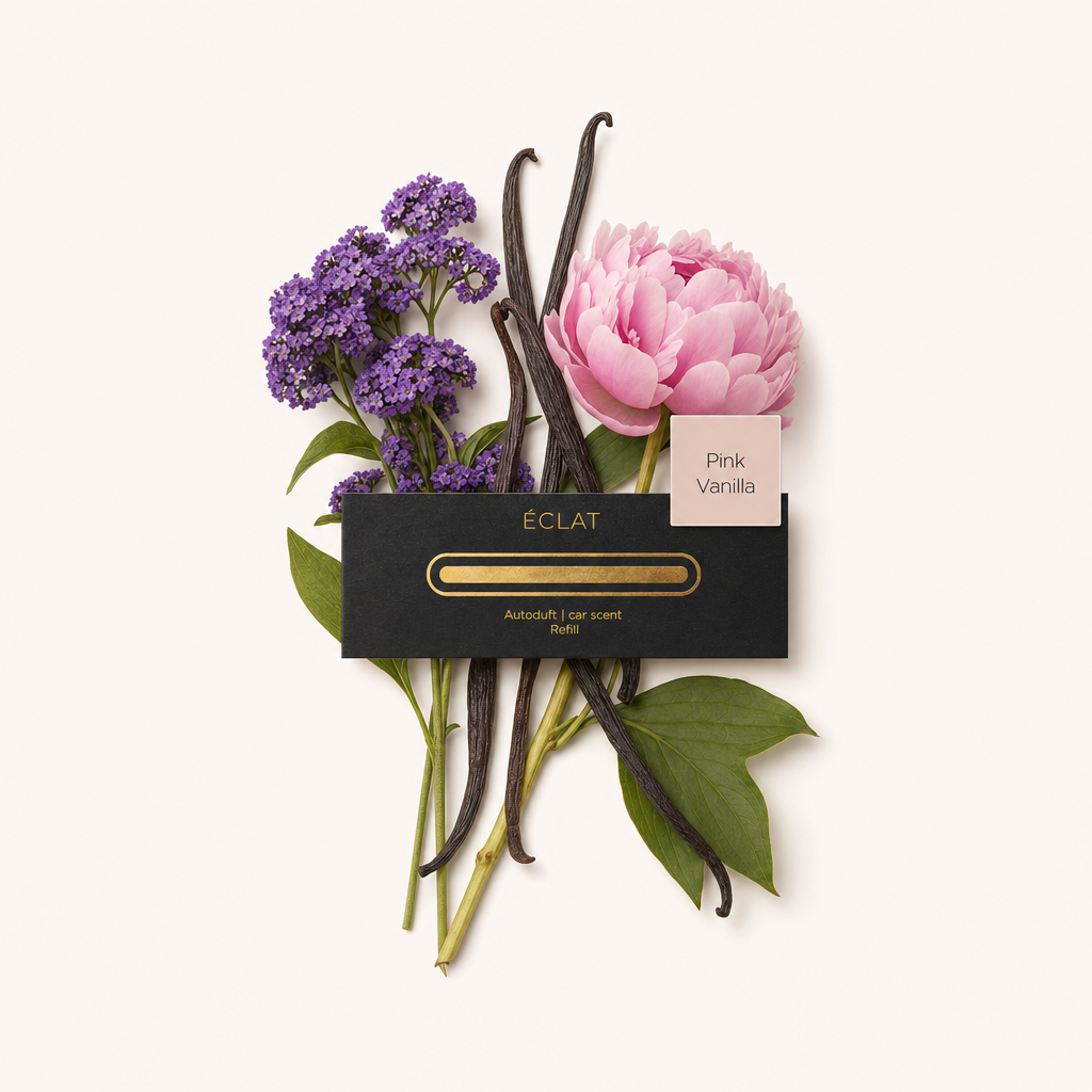 Un bouquet con fiori viola, peonia rosa e baccelli di vaniglia scuri circonda un tappo nero con etichetta ÉCLAT 'Pink Vanilla'.
