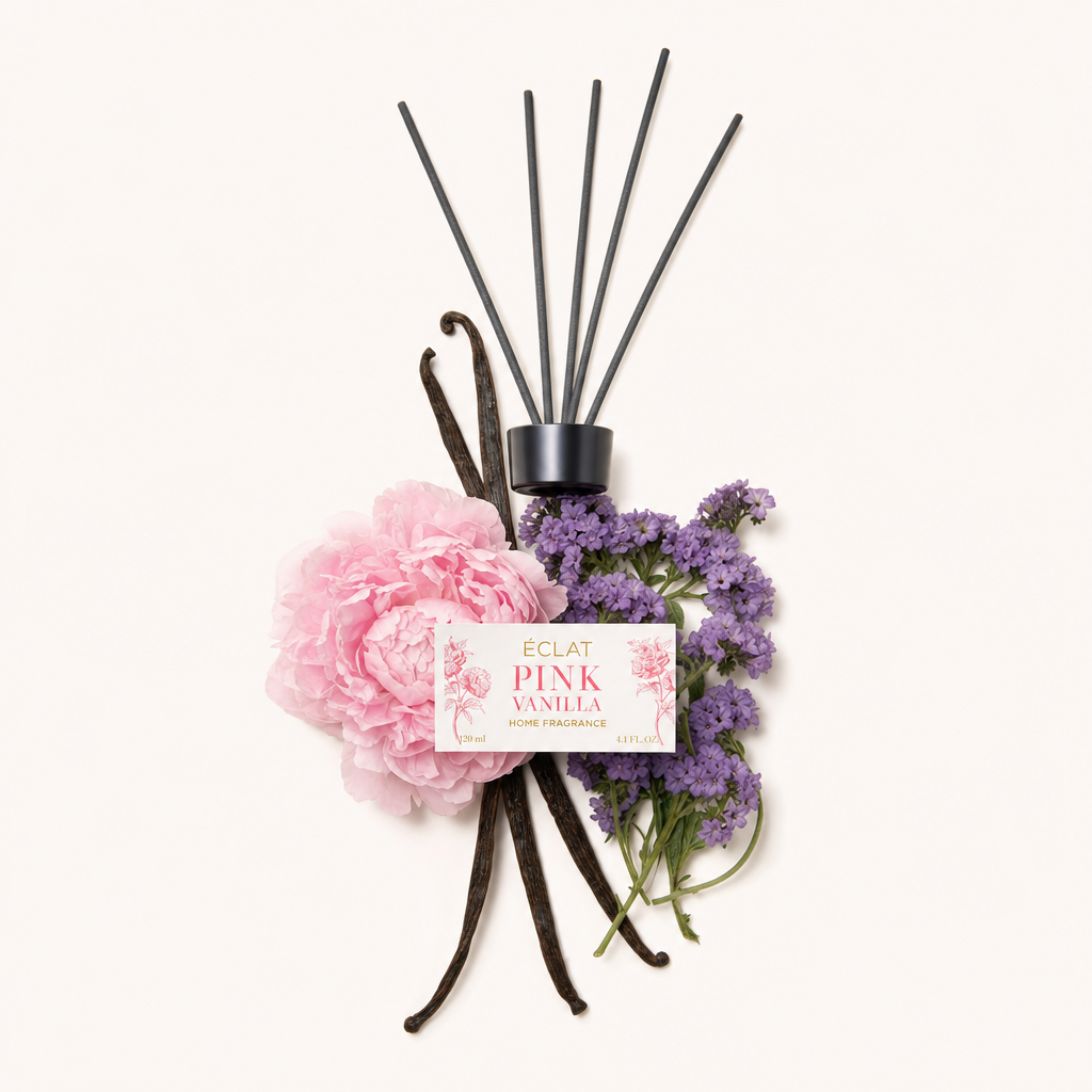 Un arrangiamento di peonie rosa, baccelli di vaniglia e ramoscelli di lavanda, attorno a un tappo nero con etichetta ÉCLAT Pink Vanilla.