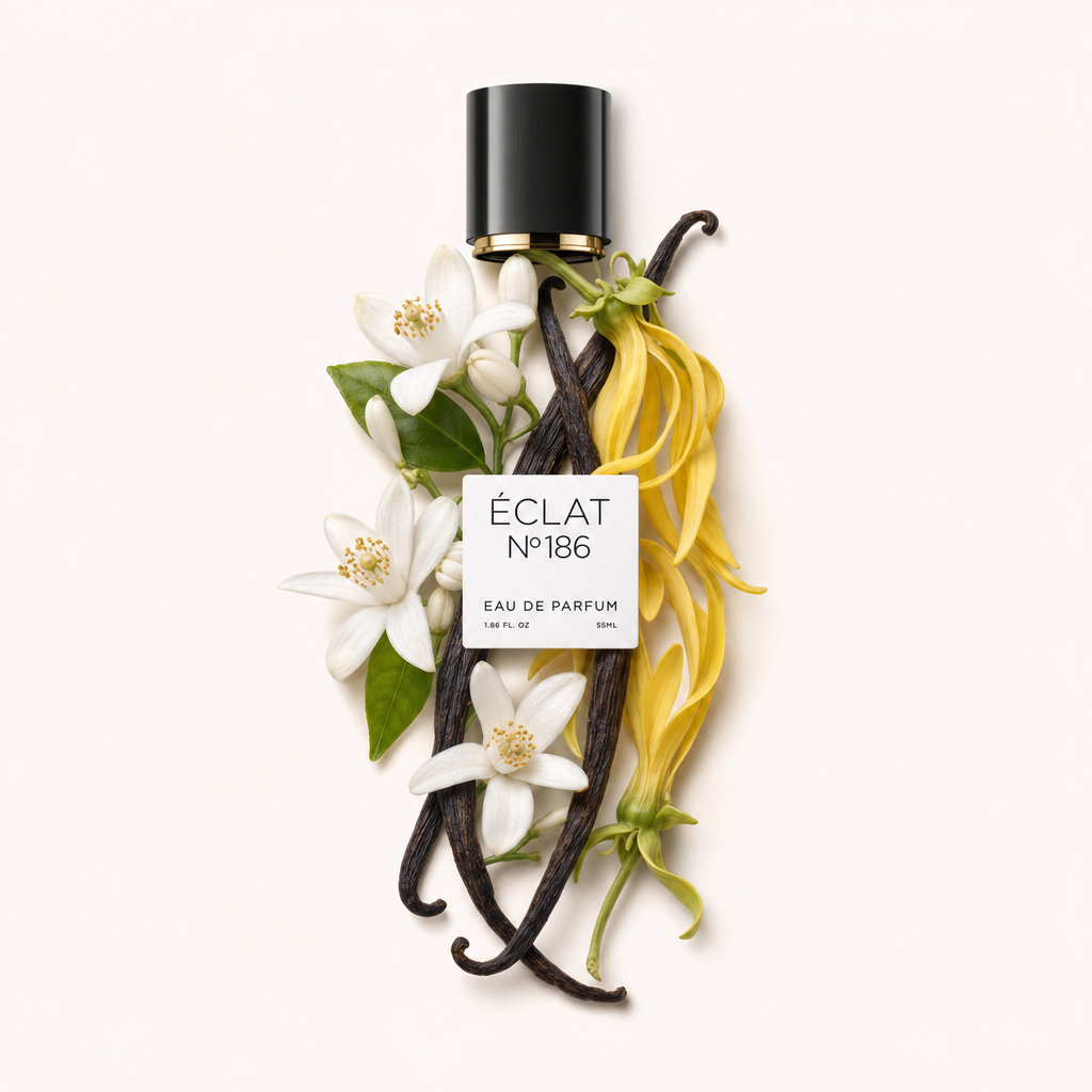 Una composizione di fiori di arancio bianchi e petali di ylang-ylang gialli, accentuata da baccelli di vaniglia scuri, circonda il tappo nero con un'etichetta di ÉCLAT Powdery Orange Blossom.