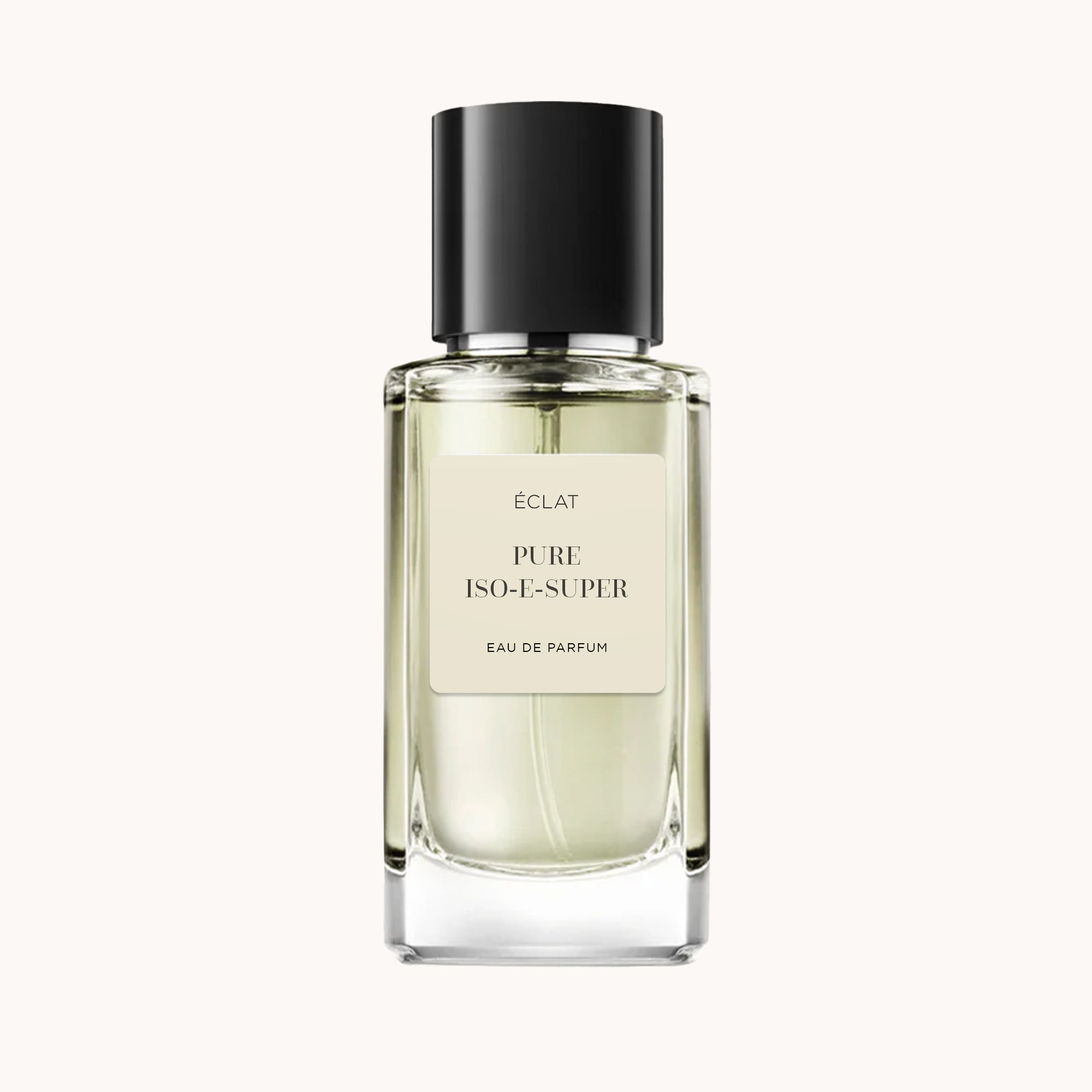 Il flacone del profumo ÉCLAT Pure Iso-E-Super presenta un design in vetro trasparente e sfaccettato con tappo nero opaco e un'etichetta minimalista.